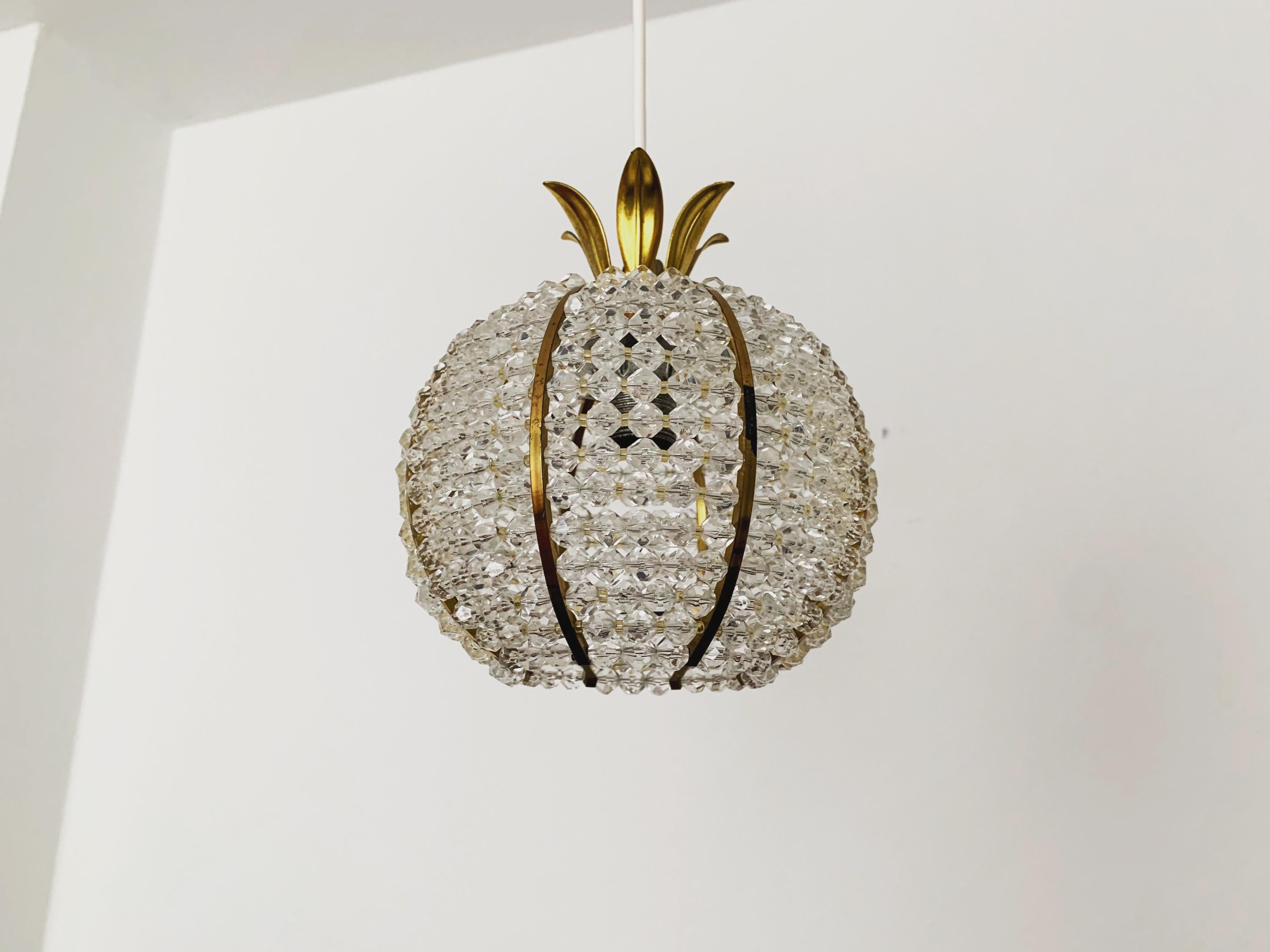 Wonderful little pendant lamp from the 1960s.
The lamp with its lavishly equipped Plexiglas balls and the brass details has a very luxurious look and sparkles particularly beautifully.
The design and the materials used create a great glittering