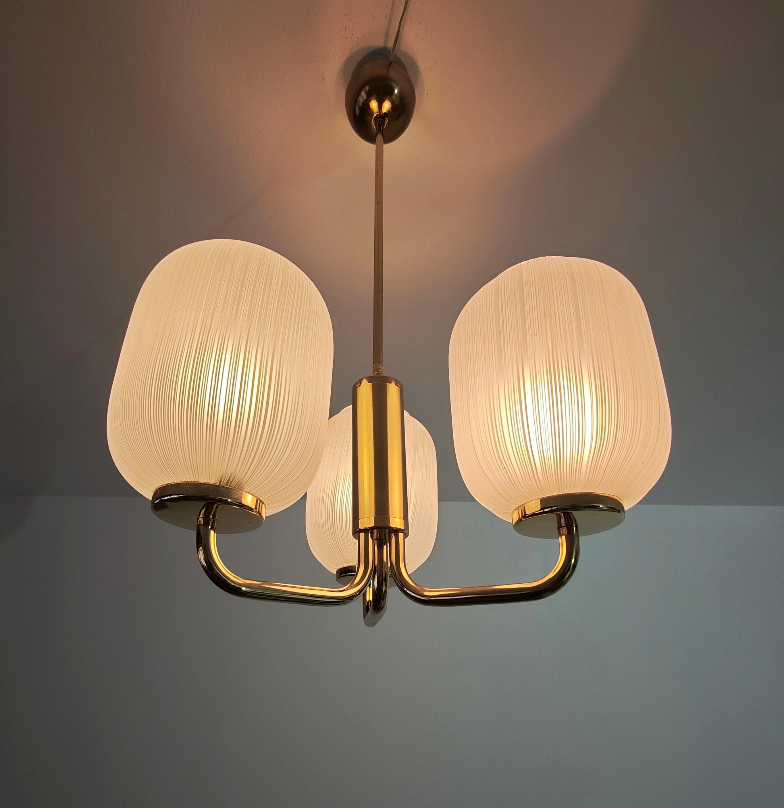 Lampada a sospensione con struttura in ottone e diffusori in vetro di Murano decorato. A tre braccia, di ottima qualità e fattura. Made in Italy, anni '70. 
Ti preghiamo di guardare attentamente il video e le foto, grazie.

Altezza del solo vetro: