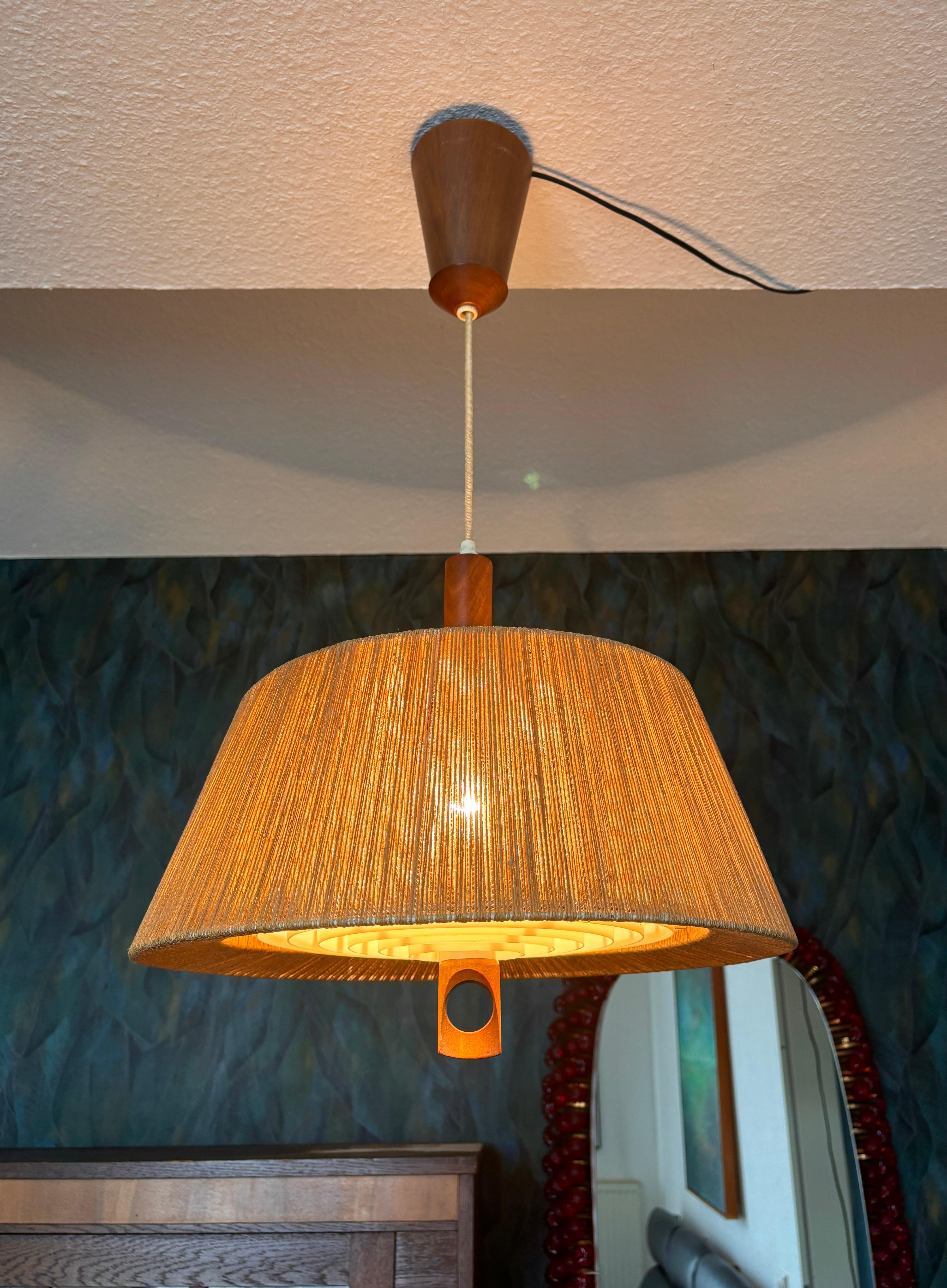 Grande lampada a sospensione in sisal di Temde, anni '60.
Lampada da soffitto di Temde in teak e sisal/raffia. La lunghezza della lampada può essere regolata grazie al meccanismo di trazione del baldacchino. Il meccanismo di trazione funziona e la