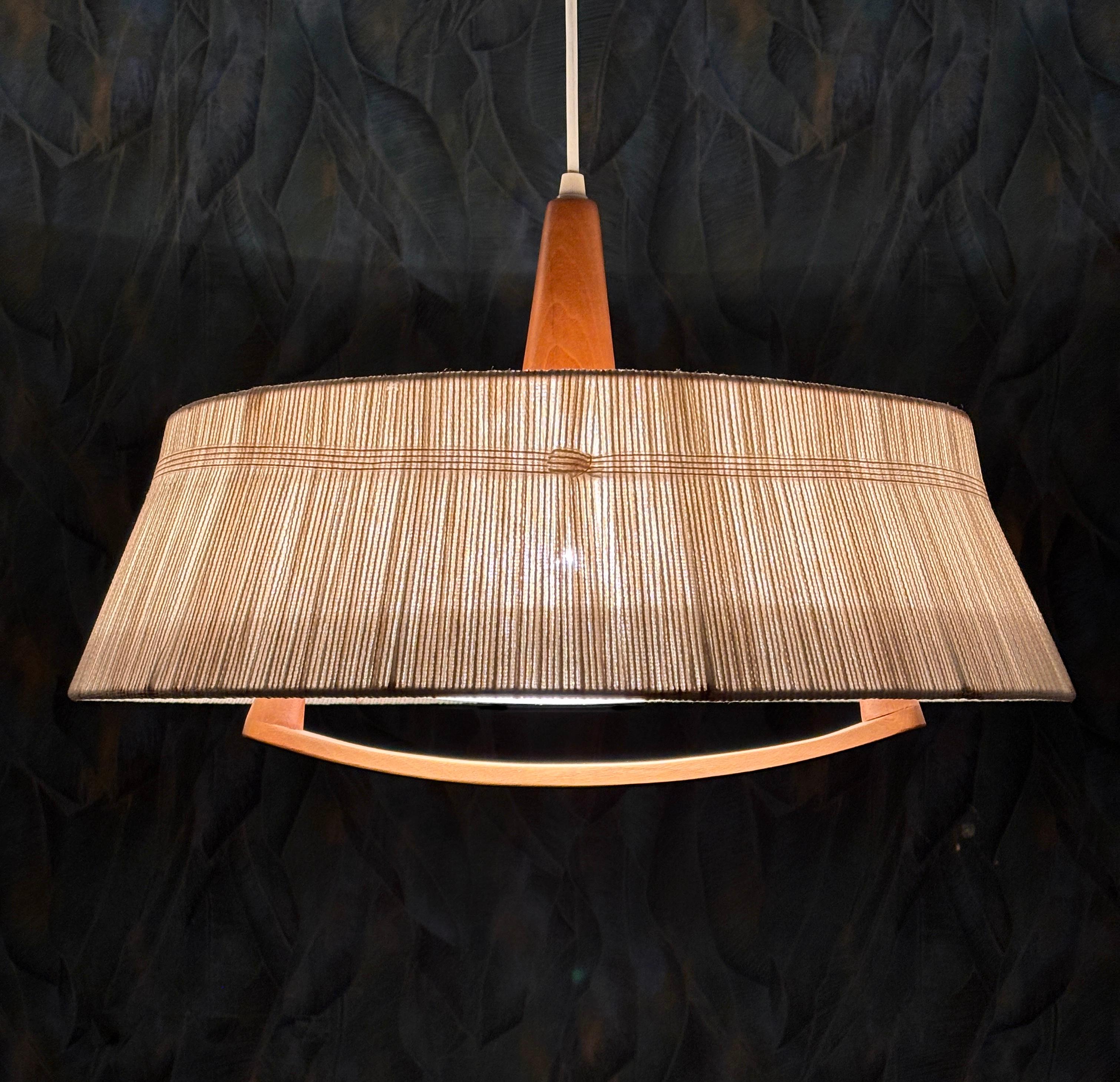 Große Sisal-Hängelampe von Temde, 1960er Jahre.
Deckenleuchte von Temde aus Teakholz und Sisal/Raffia. Die Länge der Leuchte kann mit dem Zugmechanismus im Baldachin verstellt werden. Der Zugmechanismus funktioniert, und die Länge der Schnur kann