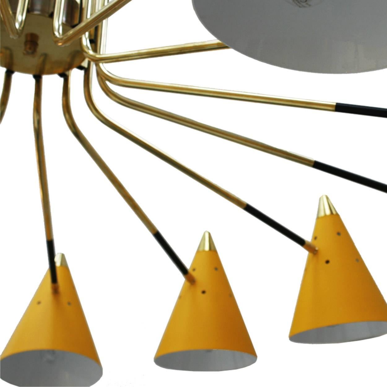 Pendant lamp midcentury style composed of fourteen points of light made of lacquered metal, conical cups and brass details.
 