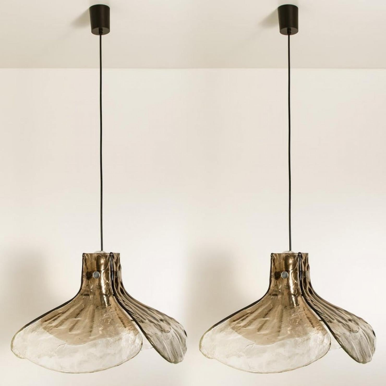 1 of the 2 pendant lamps, model LS185 by Carlo Nason for Mazzega.
Four crystal clear and smoked leaves compose this beautiful handmade piece of thick Murano glass.

Measures: H 16.93” (43 cm), D 23.62