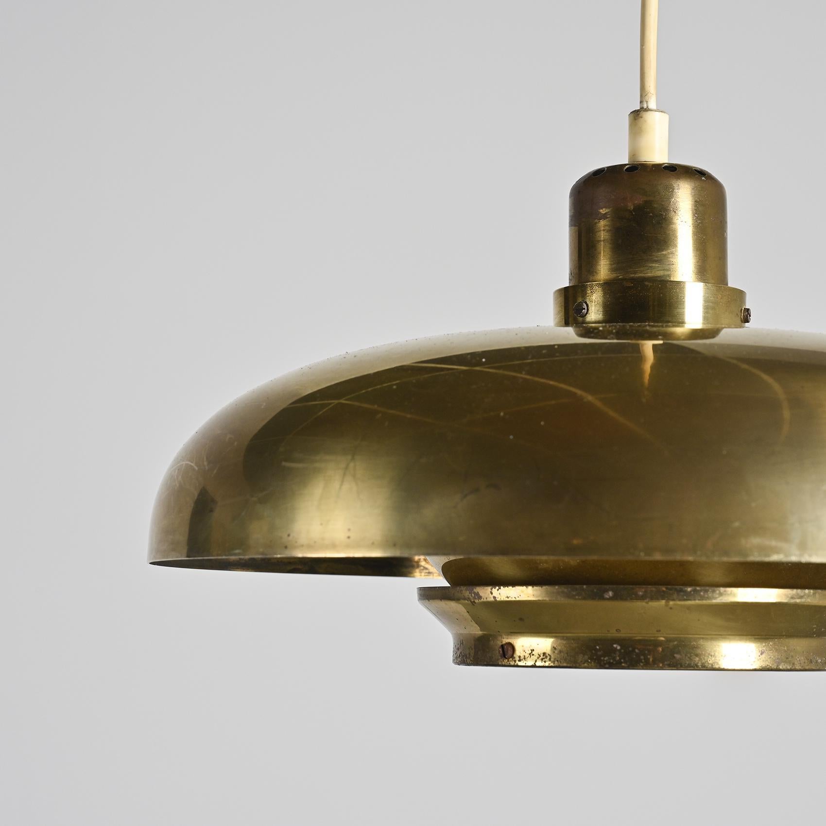 
Lampe suspendue vintage conçue par Hans-Agne Agnes vers 1960 et produite en Suède par AB Markaryd. Fabriquée en laiton massif avec une série d'anneaux concentriques, la lampe illustre le travail de Jakobsson sur la lumière diffuse, produisant une