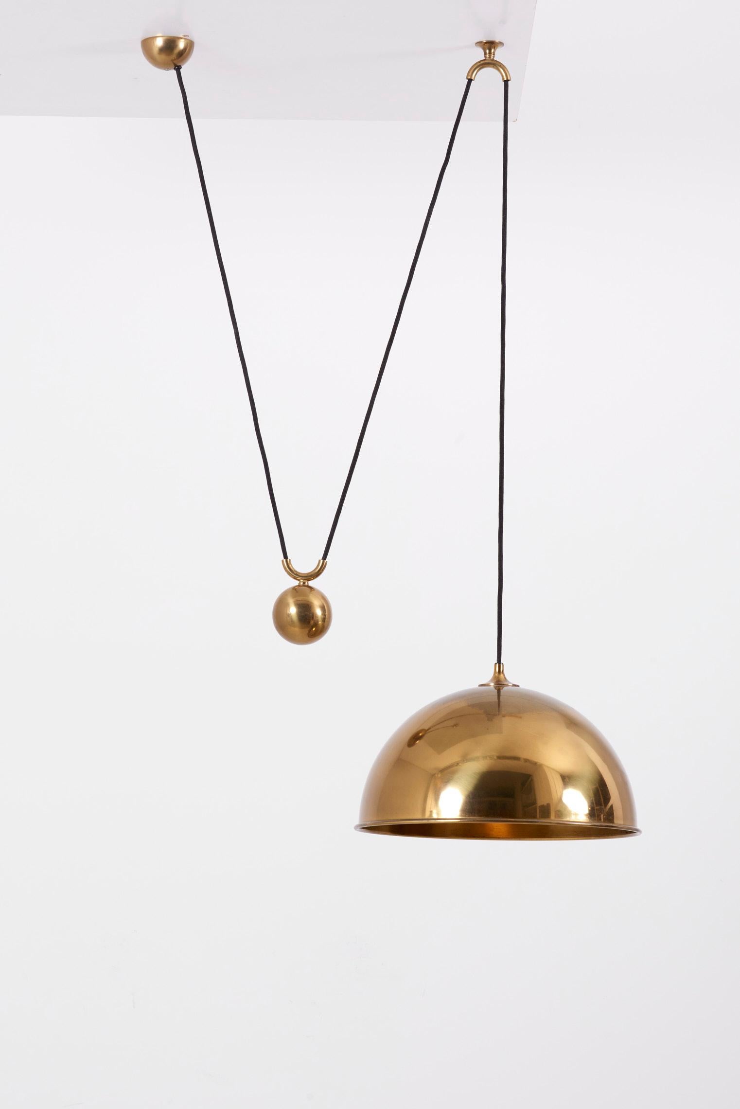 A height adjustable pendant lamp by Florian Schulz, Germany. The fixture is made of solid brass which has an aged surface in a rich and warm tone. The height can be adjusted in any position depending on the installation. Given measurements are just