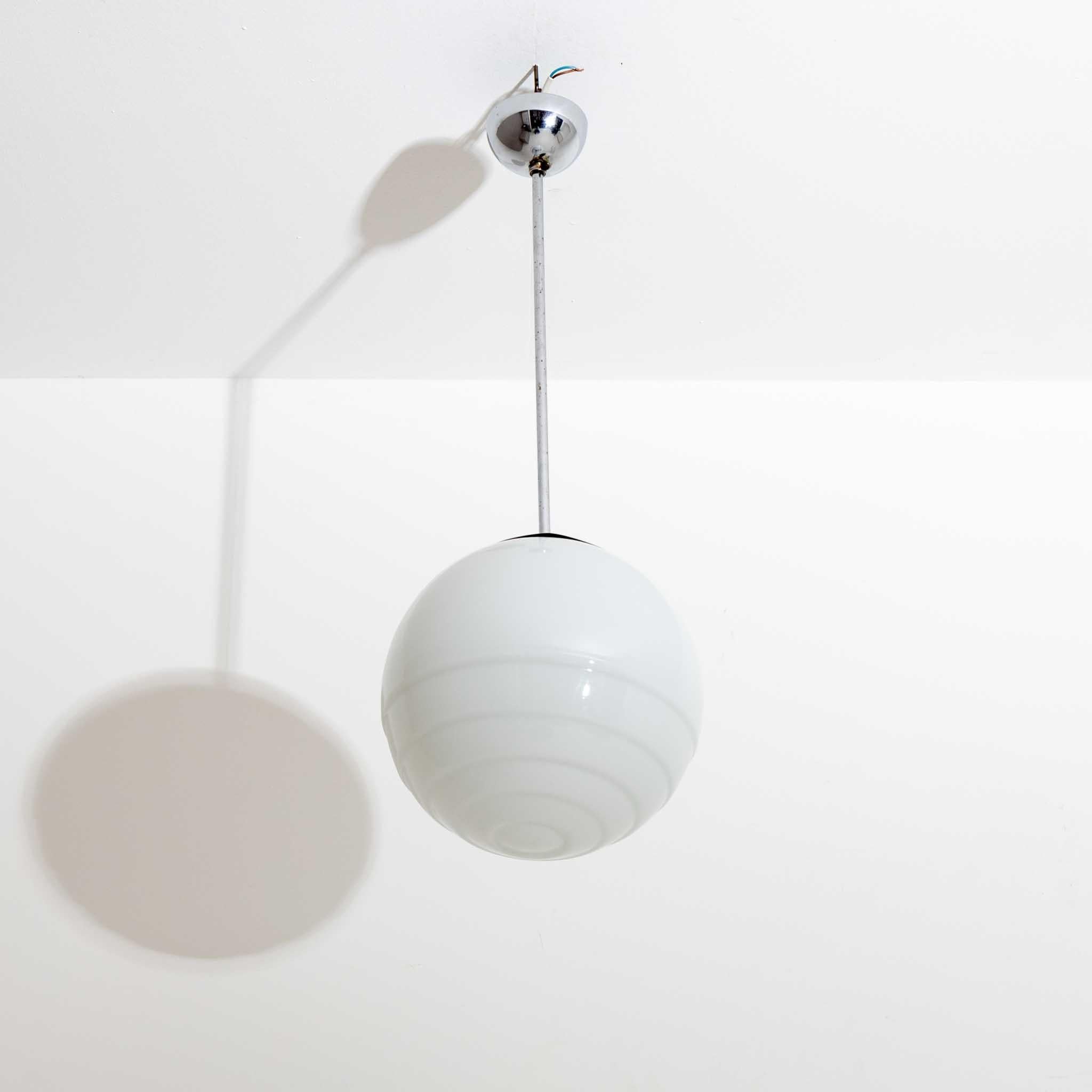 Pendant lamp made of chromed metal and frosted glass shade in the shape of a ball with three grooves.