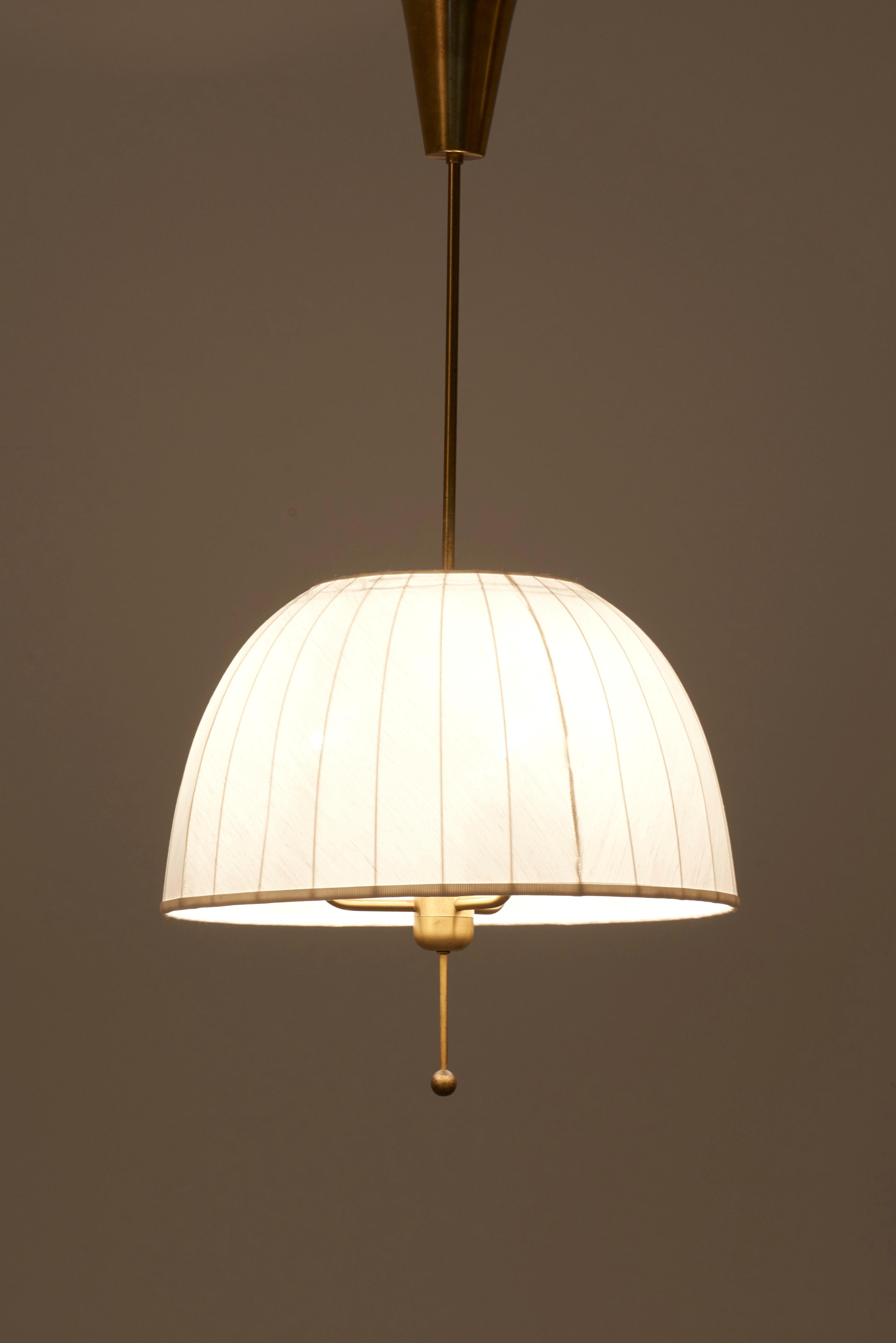 Pendant lamp, model T549, in brass designed by Hans-Agne Jakobsson in 1960s and manufactured by AB Markaryd in Sweden. The fabric of the lamp shade in off-white chintz is new.

3 x E27 sockets.

Please note: Lamp should be fitted professionally