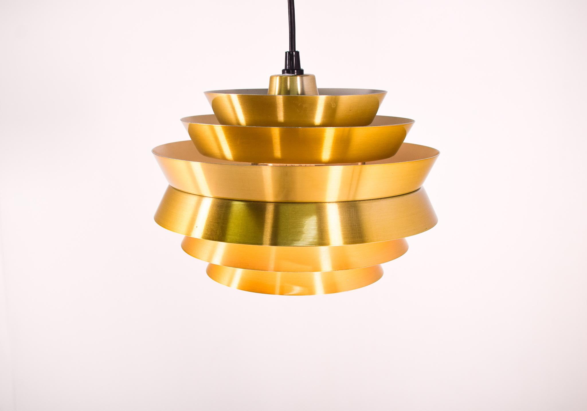 Iconic Swedish trava pendant designed by Sigurd (Carl Thore) Lindkvistfor for Granhaga Metallindustri. It’s finished in shades of metallic brass colour and the innermost shades are lacquered white on the inside so it emits a wonderful glow when lit.