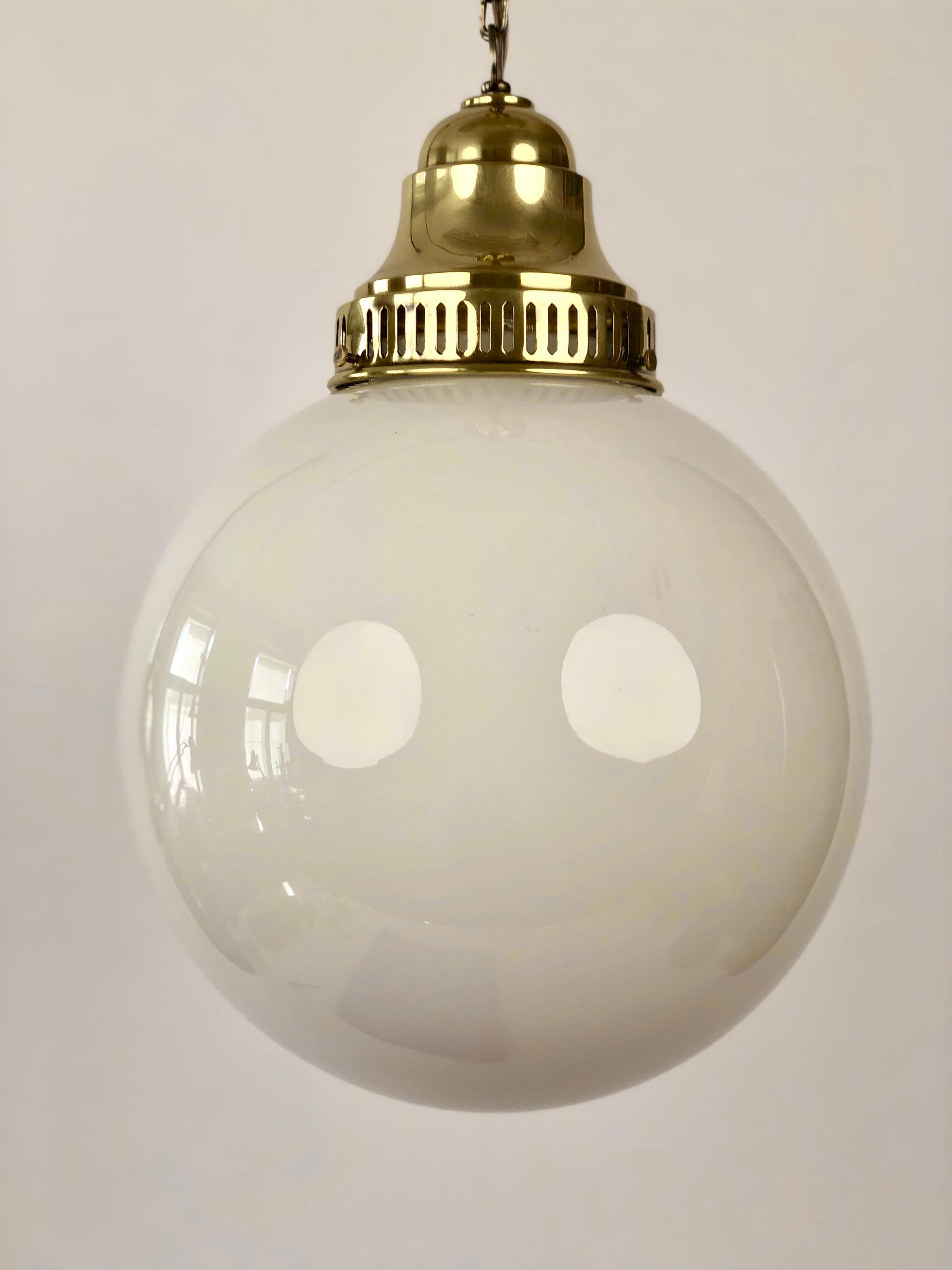 A beautiful Jugendstil brass pendant lamp with an opaline glass globe.
All the brass elements have been professionally restored, polished and sealed with hand applied lacquer .
What i love about the lamp is the ornate chain made from pressed brass