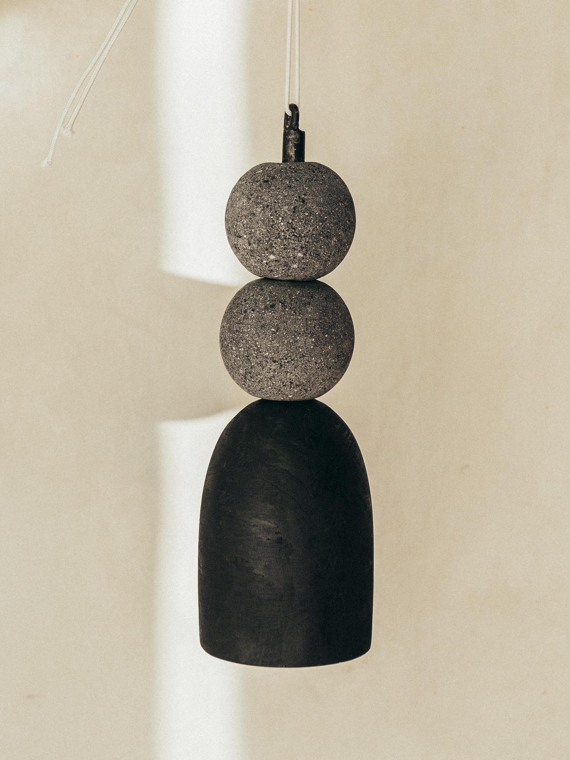 Pendant lamp with volcanic stone balls and burnt wood by Daniel Orozco.
Dimensions: D 13 x H 40 cm.
Materials: Wood, Volcanic Stone.

All our lamps can be wired according to each country. If sold to the USA it will be wired for the USA for