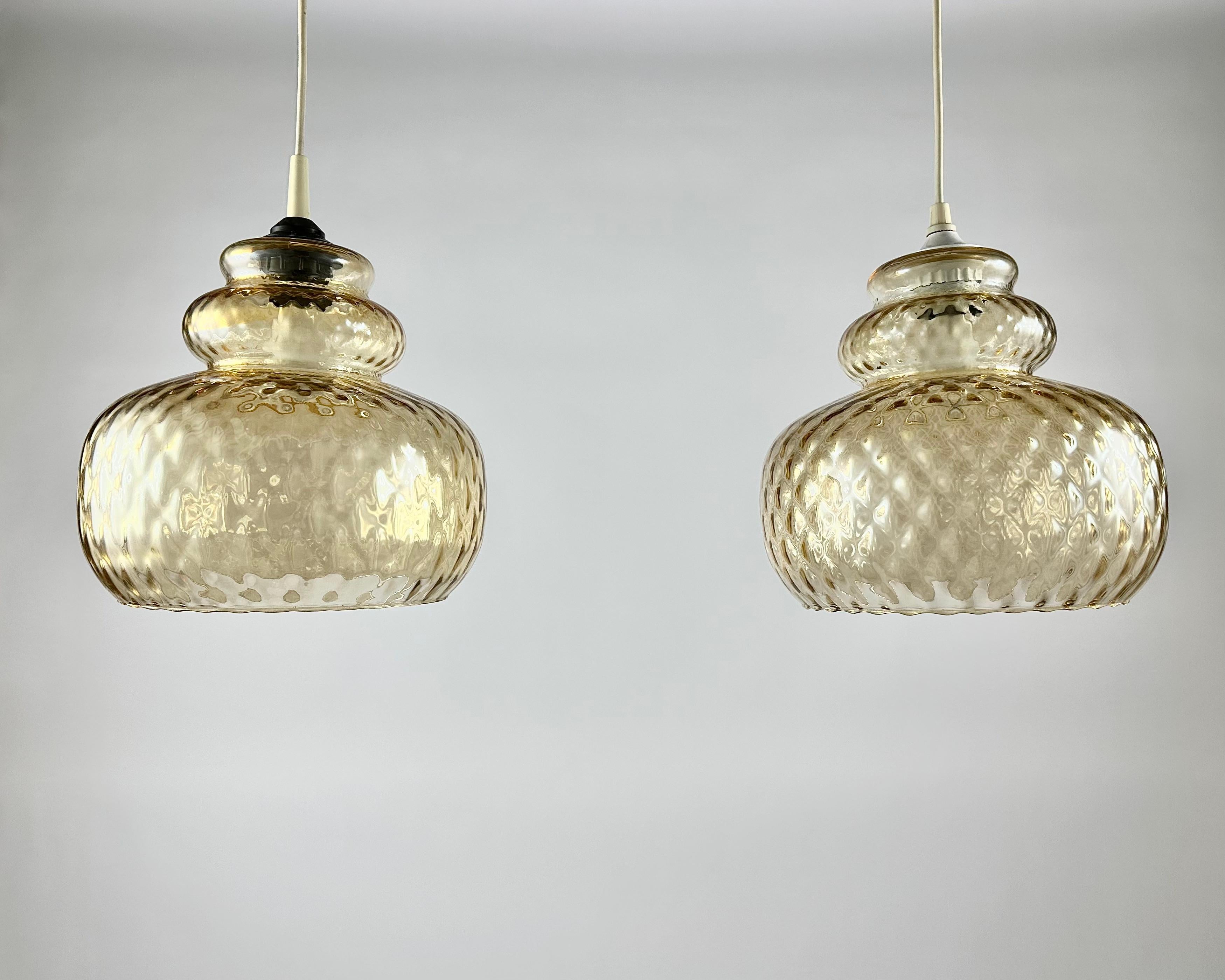 Very beautiful pendant lights with vintage amber glass ball.

Germany, 1970s.

Beautifully detailed, vintage lights in iridescent amber glass ball with facets.

Attractive amber glass vintage lamps that can be used as an accent in the interior and