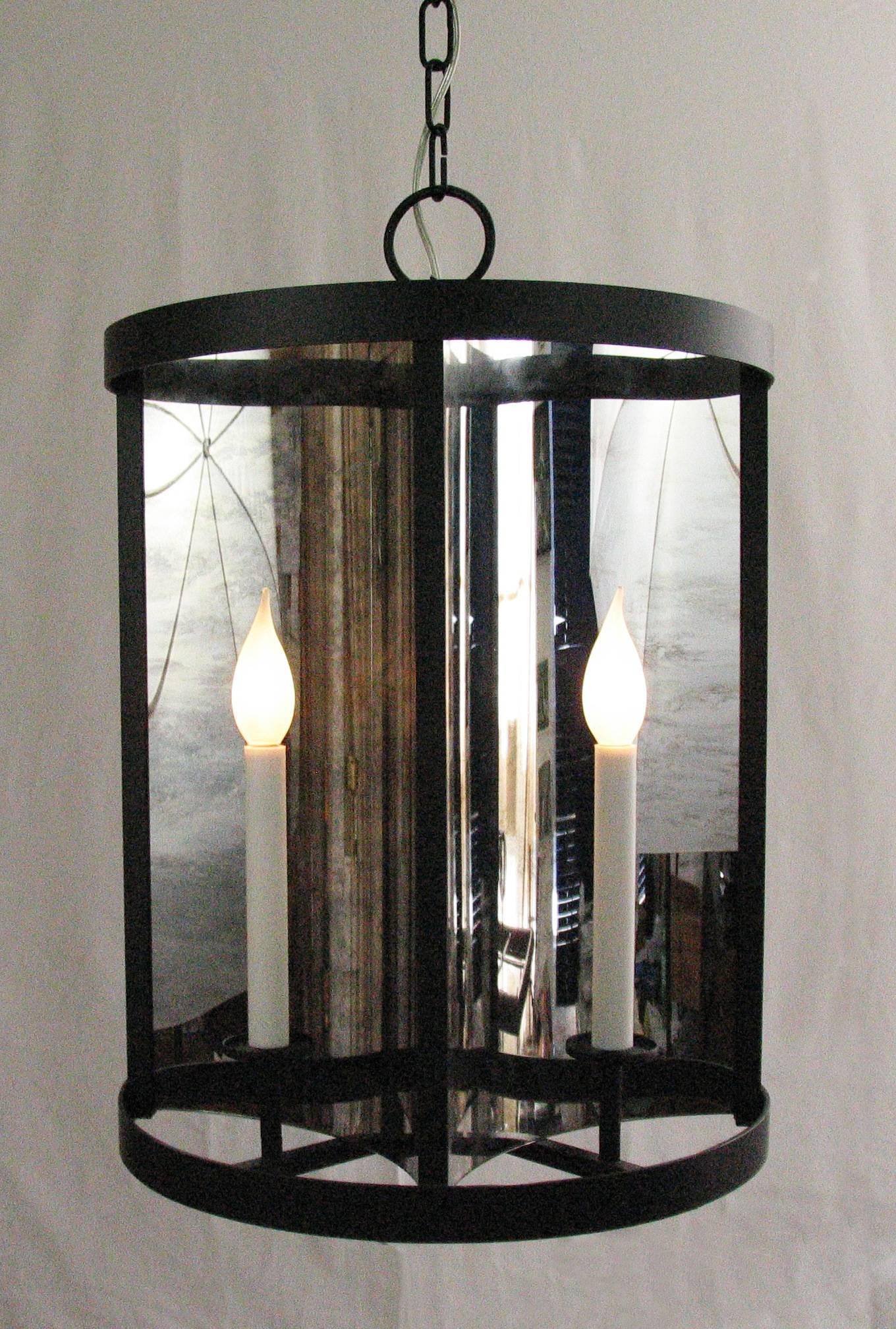 A pendant, lantern made of four curved, antiqued, silvered mirror glass that distort the candles reflections - like the funhouse, circus mirrors.
Handmade in Italy. Matte black.