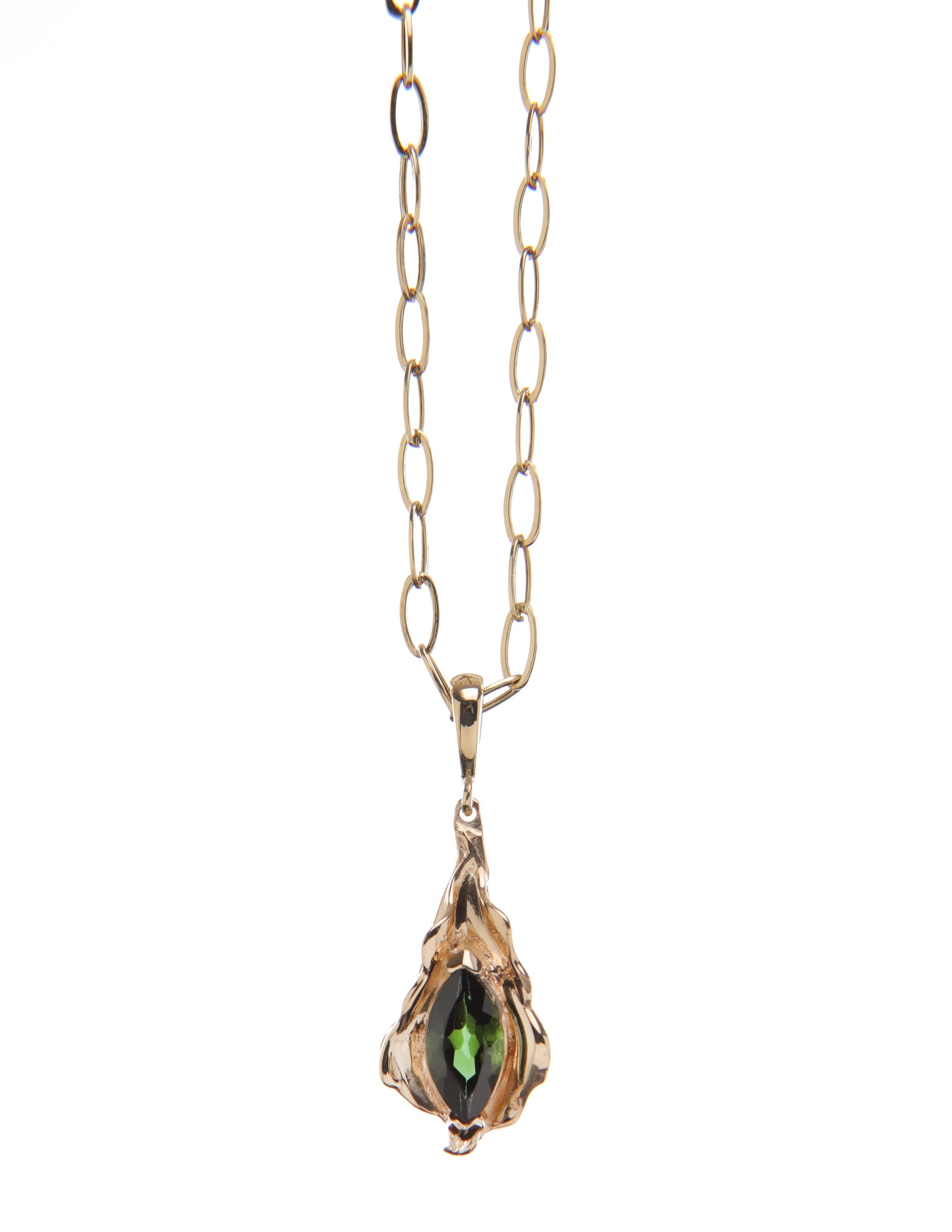 Yellow gold and green tourmaline leaf charm flutters naturally. 

