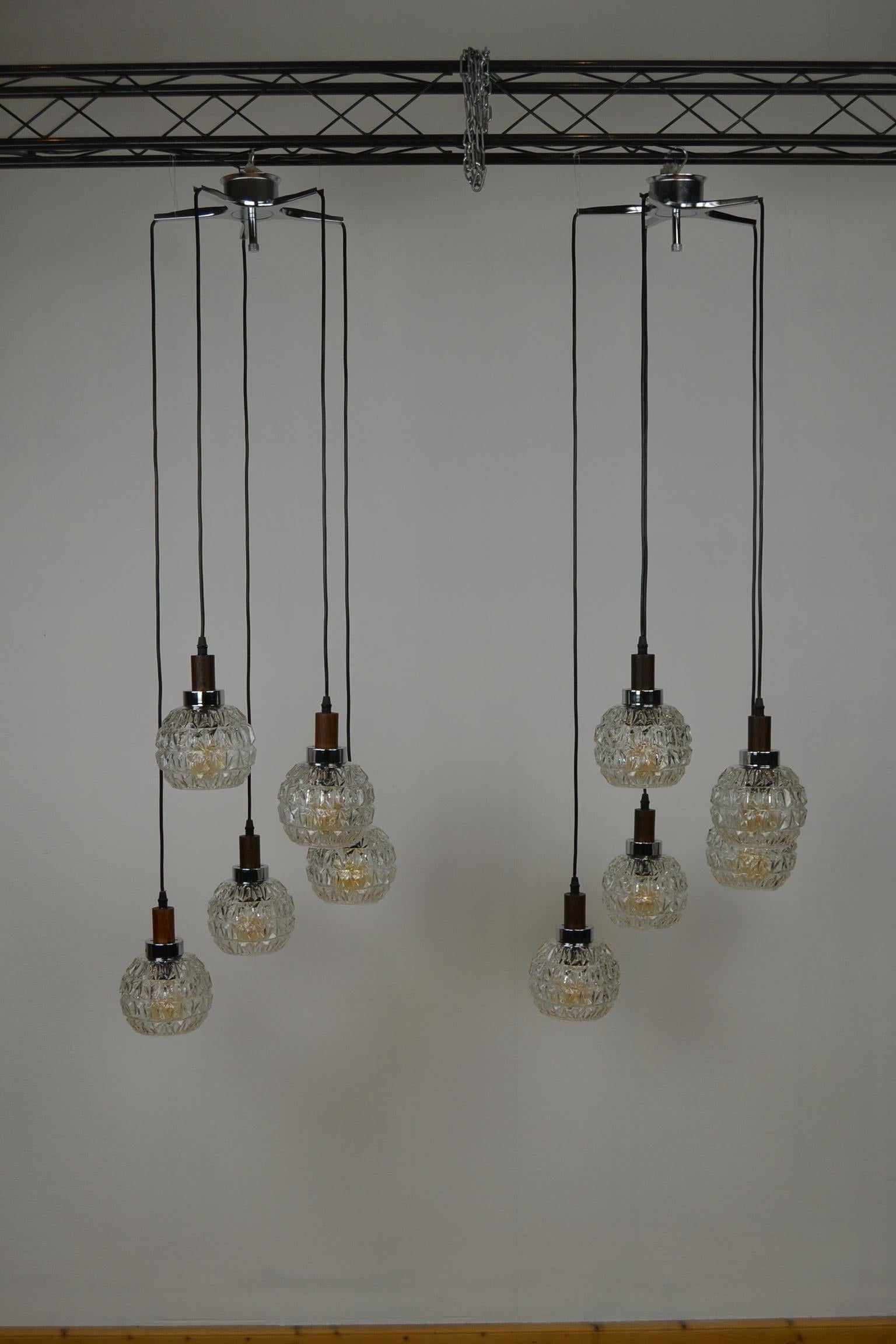 Midcentury pendant lights with each 5 lights.
Each pendant light has a star shaped metal suspending, 5 wiring at different heights with an open art glass shade with chromed ring and wooden hanging.
Each light points needs an E27 bulb.

These vintage