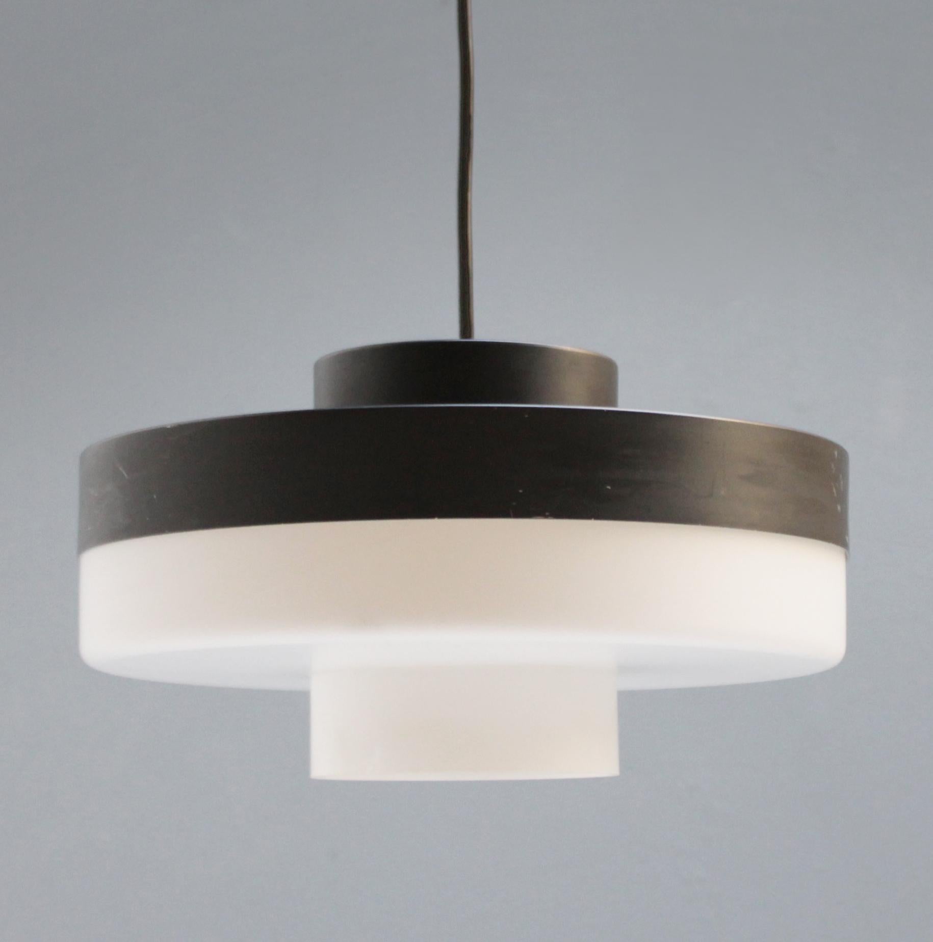Rare stylish pendant light, model B-1045 by the French/Finnish designer Li Helo for Raak Amsterdam, 1968. Opaline glass with anthracite lacquered metal.
Dimension: height (16 cm), diameter (30 cm). One bulb E27/E26 of max 100 watt, the wire is used