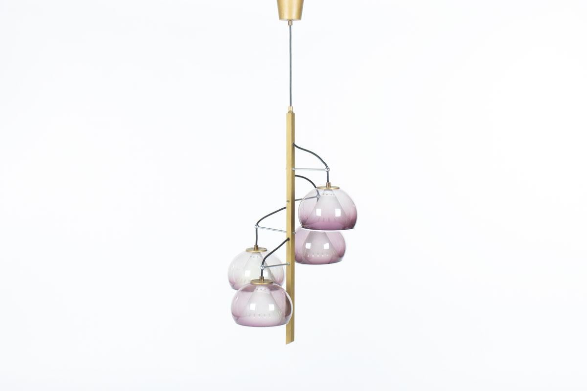Suspension éditée par Stilux dans les années 60 en Italie
Composé d'un support sur lequel repose un câble noir et d'un bras vertical en métal doré. 
La lumière est réfléchie grâce à 4 points lumineux composés d'un abat-jour en plexiglas gris/violet