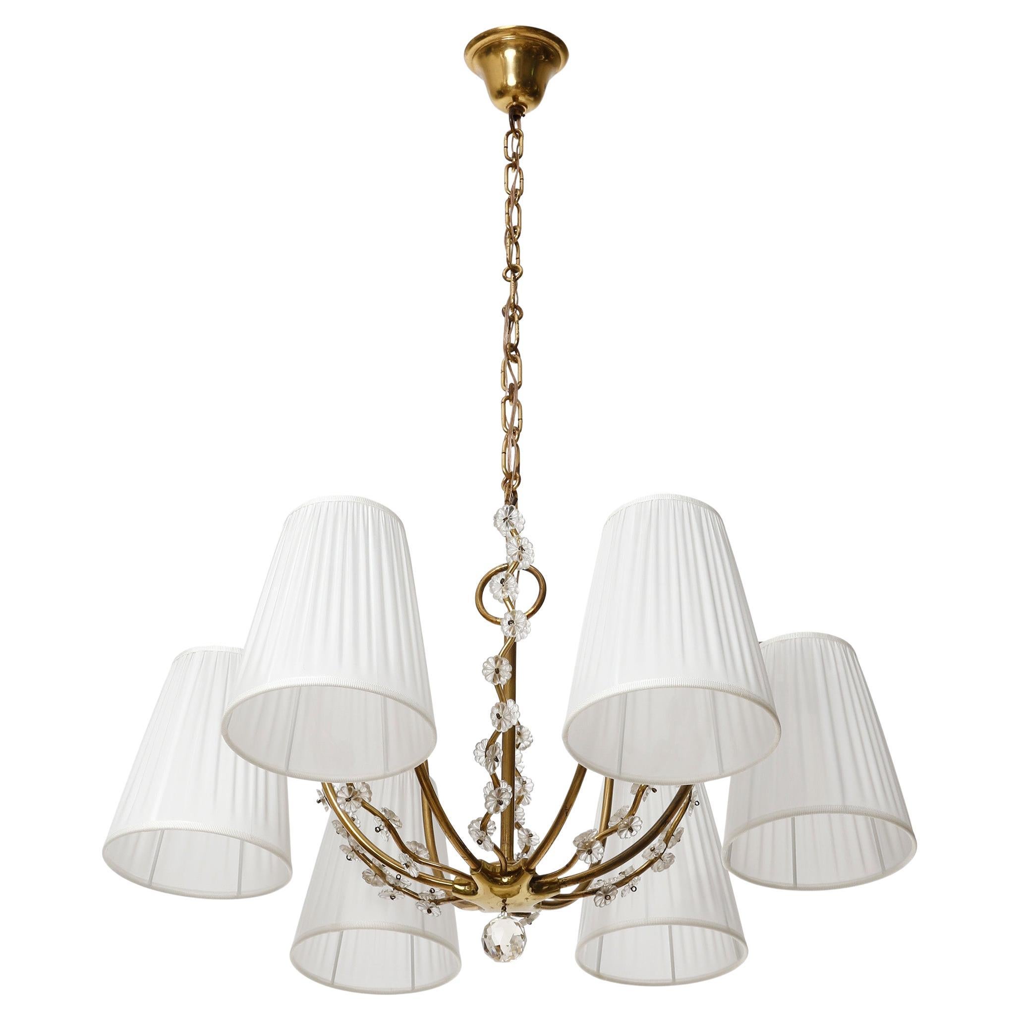 A fantastic six-arm pendant chandelier made of brass and white pleated silk shades, manufactured in Austria c.a 1960 (late 1950s or early 1960s).
The organically curved arms are decorated with cut glass pieces. The brass parts have lovely patina and