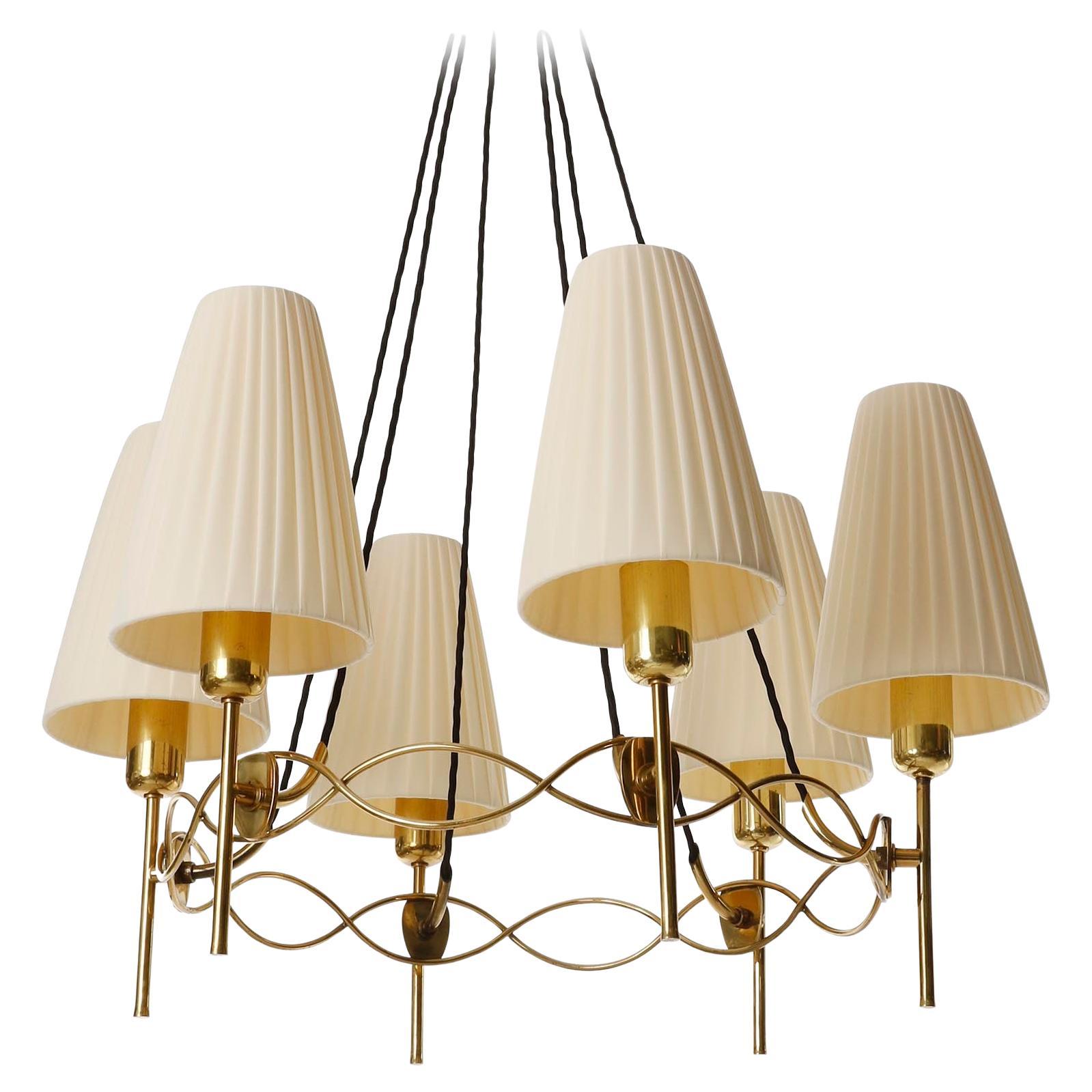 Un fantastico lampadario in ottone con paralumi in tessuto plissettato color crema attribuito a J.T. Kalmar prodotta in Austria negli anni '50.
Le parti in ottone sono in ottime condizioni originali con patina e hanno una calda tonalità