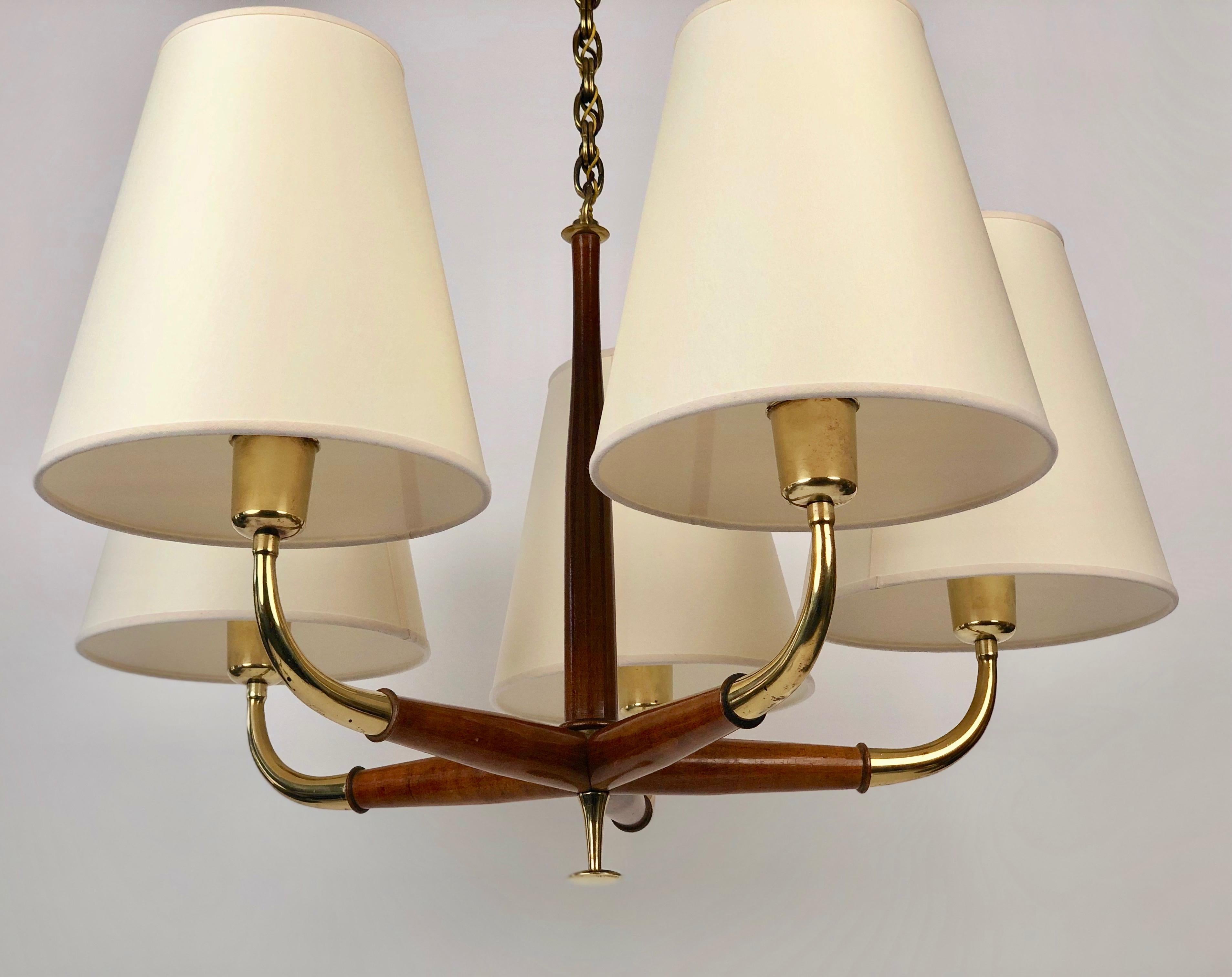A beautiful five arm pendant lamp from Josef Frank in brass and walnut.
The wood and brass elements exhibit a lovely patina giving the lamp a visual warmth.

The lamp shades are new, made from paper, based on the original shades.

The electric has