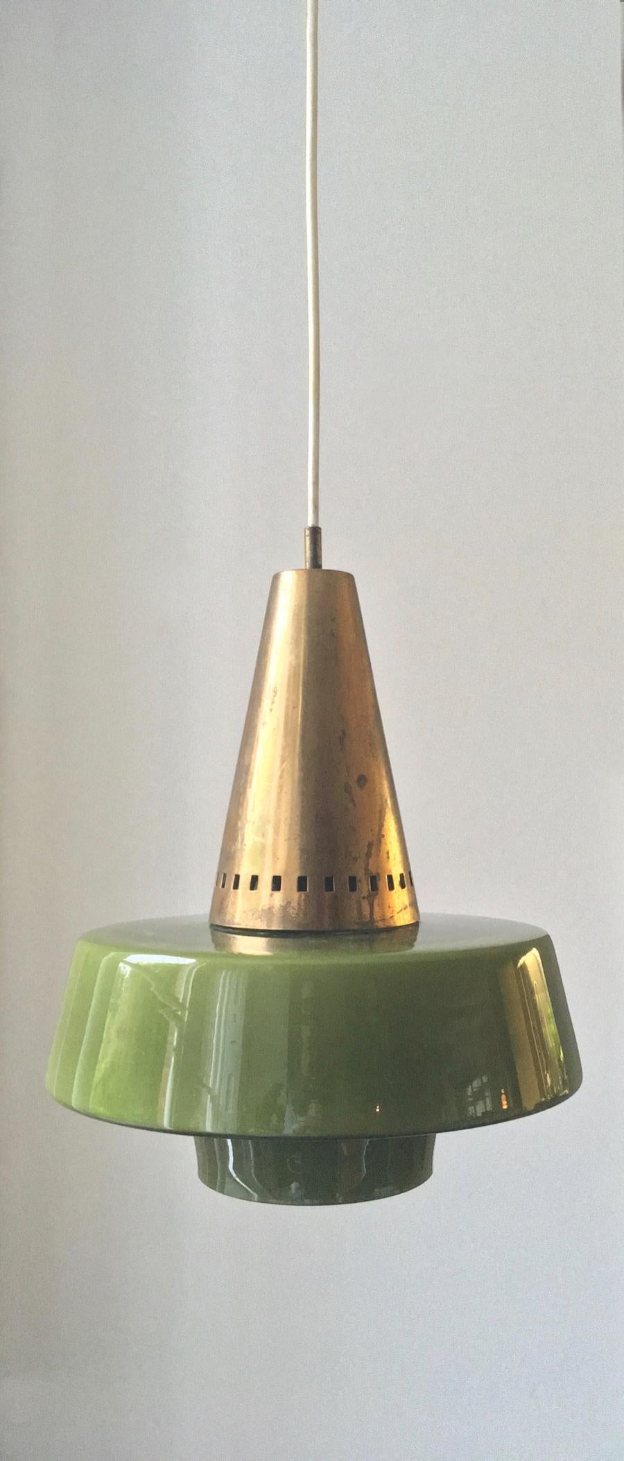 A ceiling pendant light of pierced brass, with green cased glass diffuser, by Stilnovo of Milan, Italy, mid-20th century, (circa 1950s). A beautiful understated fixture, very nicely made, in good vintage condition. Very unusually, the fixing bears