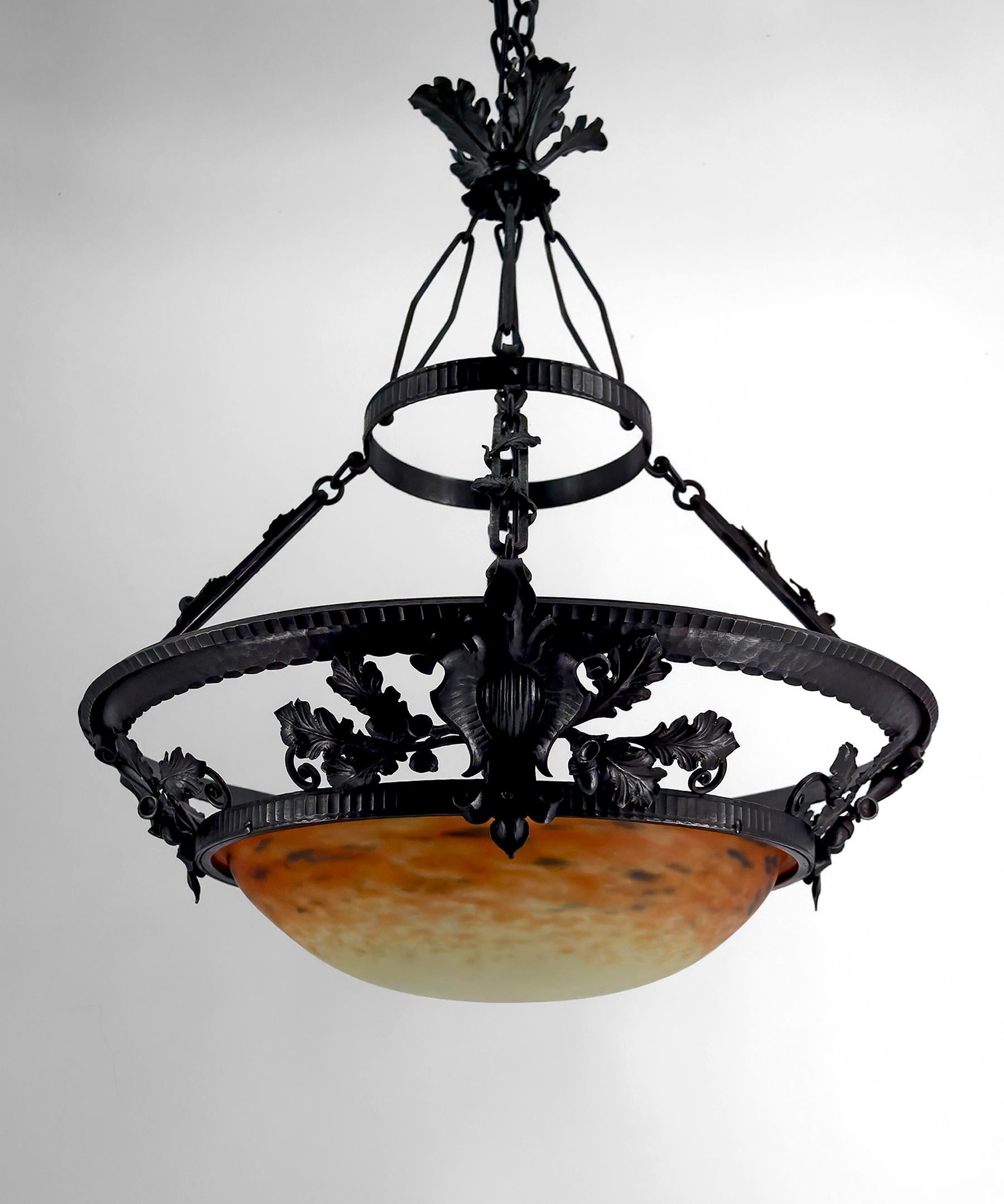 Lampadario / Lampada a sospensione in ferro battuto e vetro soffiato in pasta, attribuito a Muller Frères Lunéville, Art Nouveau / Art Déco, Francia, circa 1900-1920.

Siamo lieti di offrirti un lampadario a sospensione di alta qualità, che