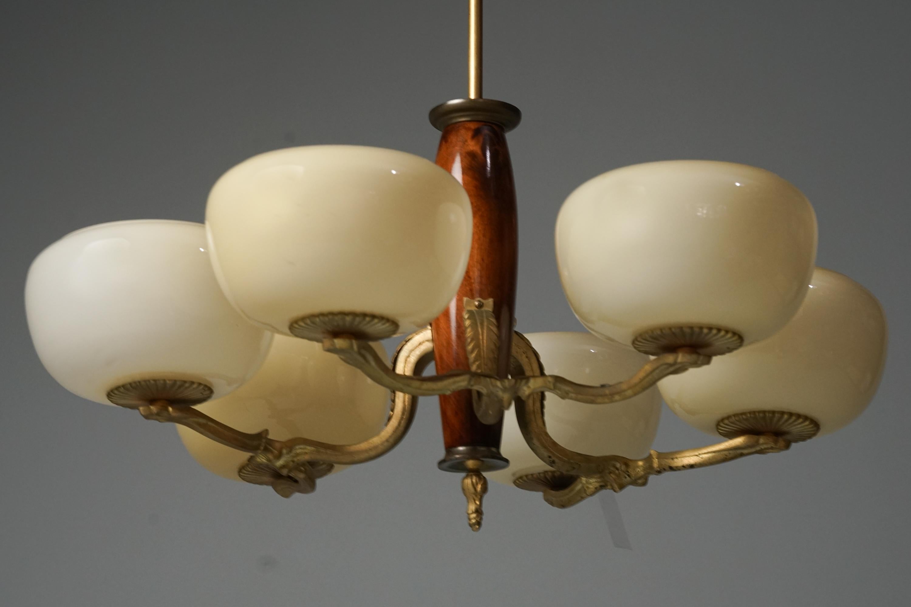 Pendant model 1855, designed by Paavo Tynell, manufactured by Taito Oy, 1930s. Stained birch frame with forged iron. Brass details. Opaline glass shades. Good vintage condition, minor patina consistent with age and use. 

Paavo Tynell (1890-1973) is