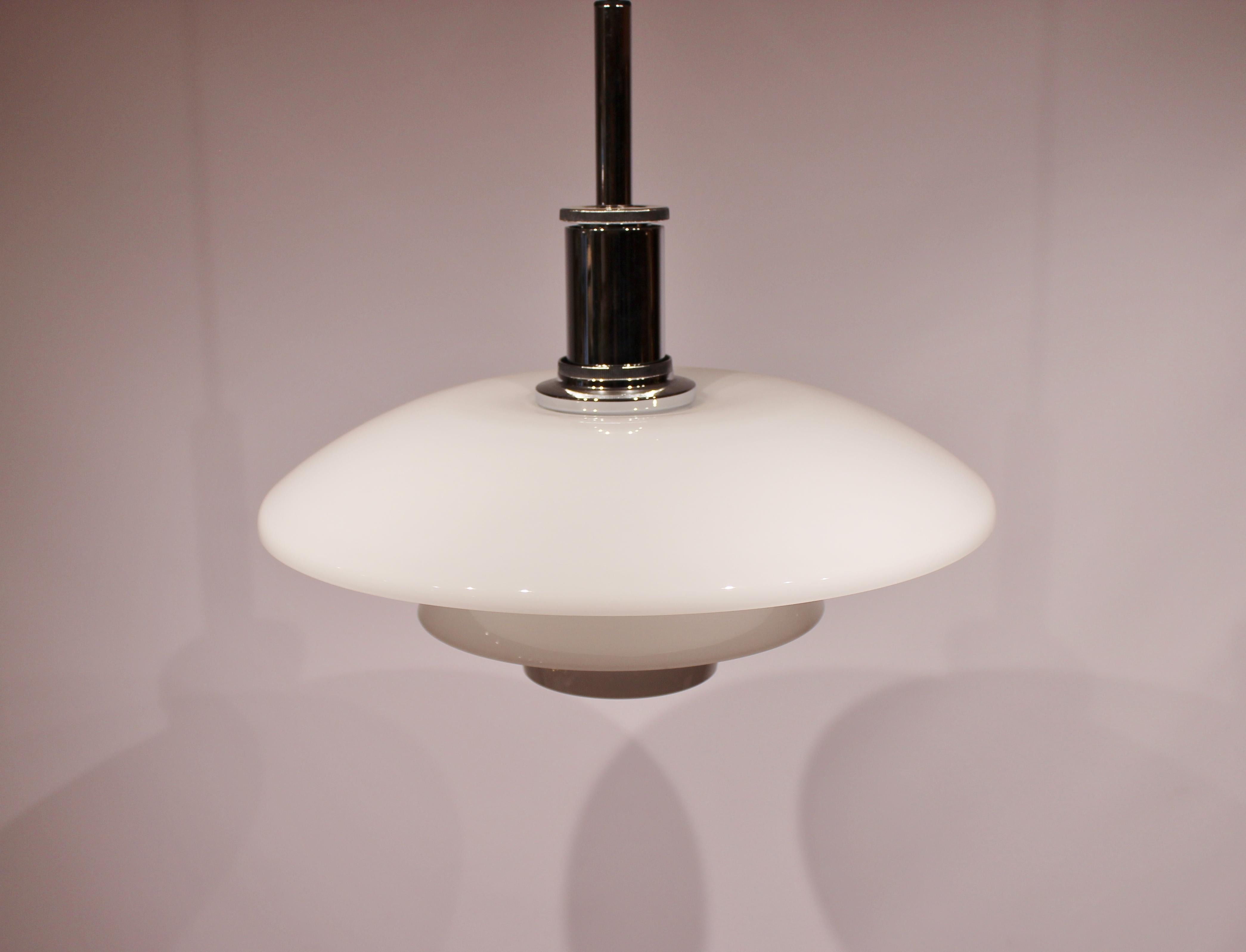 Pendant, model 4½-4, of white oplaine glass and chrome, designed by Poul Henningsen and manufactured by Louis Poulsen. The lamp is in great vintage condition.