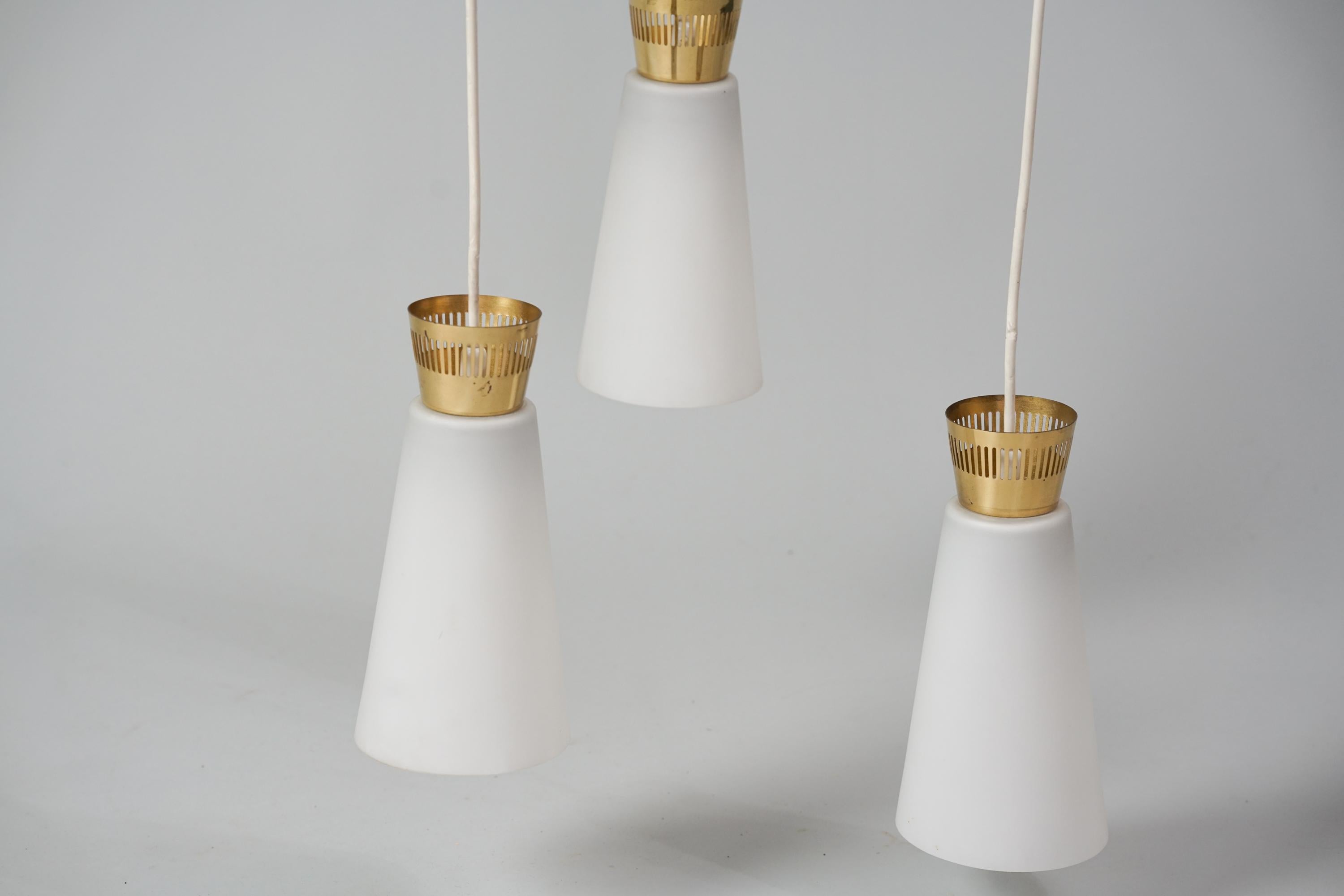 Pendant Model ER 122/3, manufactured Itsu, 1950/1960s. Milk glass shades, brass details. Marked. Good vintage condition, patina consistent with age and use. 


