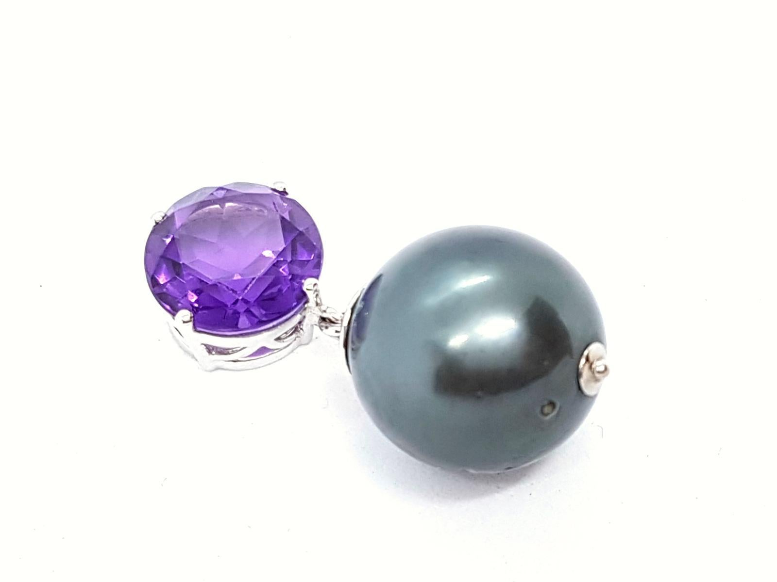 Pendant handmade. mounted on white gold 750 mils (18 carats). a Tahitian pearl magnificent diameter 1.5 cm. and a round amethyst. about 4.47 cts. size: 3 cm x 1 cm. total weight: 7.61 g. new. new price: 2220 €
