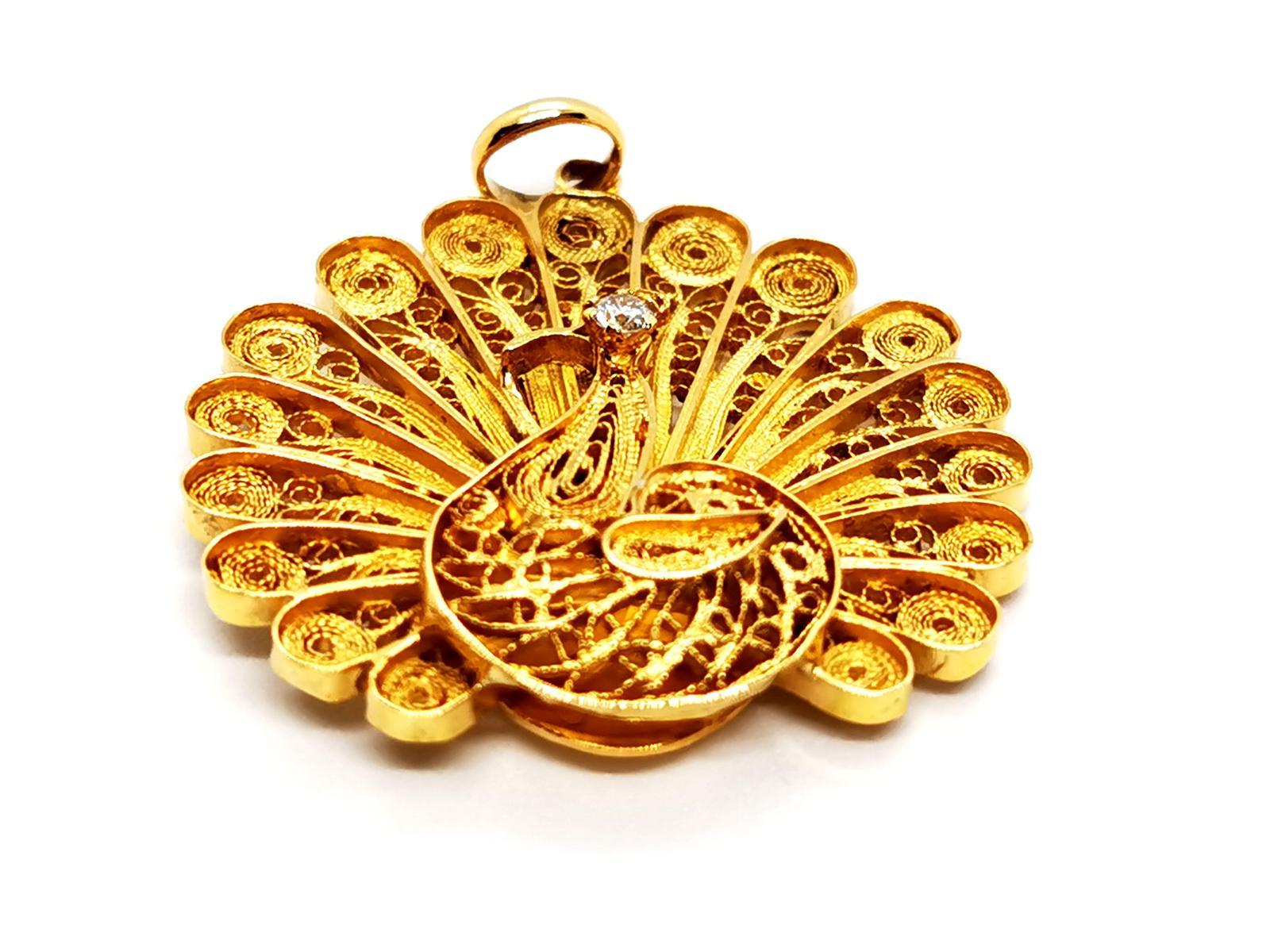 Peacock pendant in yellow gold 750 thousandths (18 carats). vintage model. peacock motif filigree set with a diamond. brilliant cut of about 0.09 ct. size (bail included): 4.4 cm x 3 . 63 cm. total weight: 14.70 g. eagle punch head on the bail