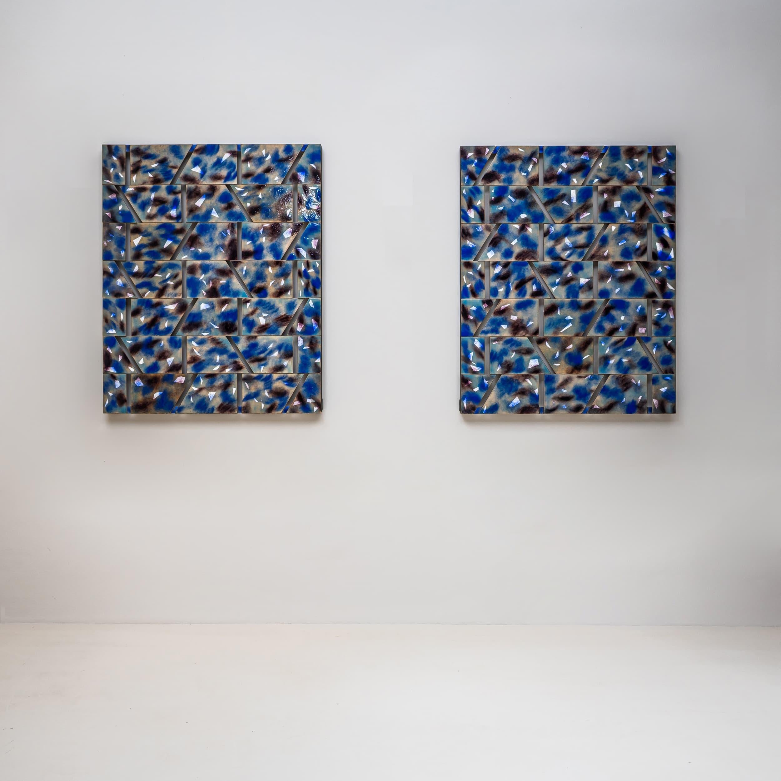 Paire de panneaux muraux rectangulaires en fer, articulés avec des surfaces trapézoïdales et des ouvertures régulièrement placées, de Paolo de Poli (Italie, 1905-1996). Les surfaces sont émaillées dans des tons bleus et rehaussées de formes