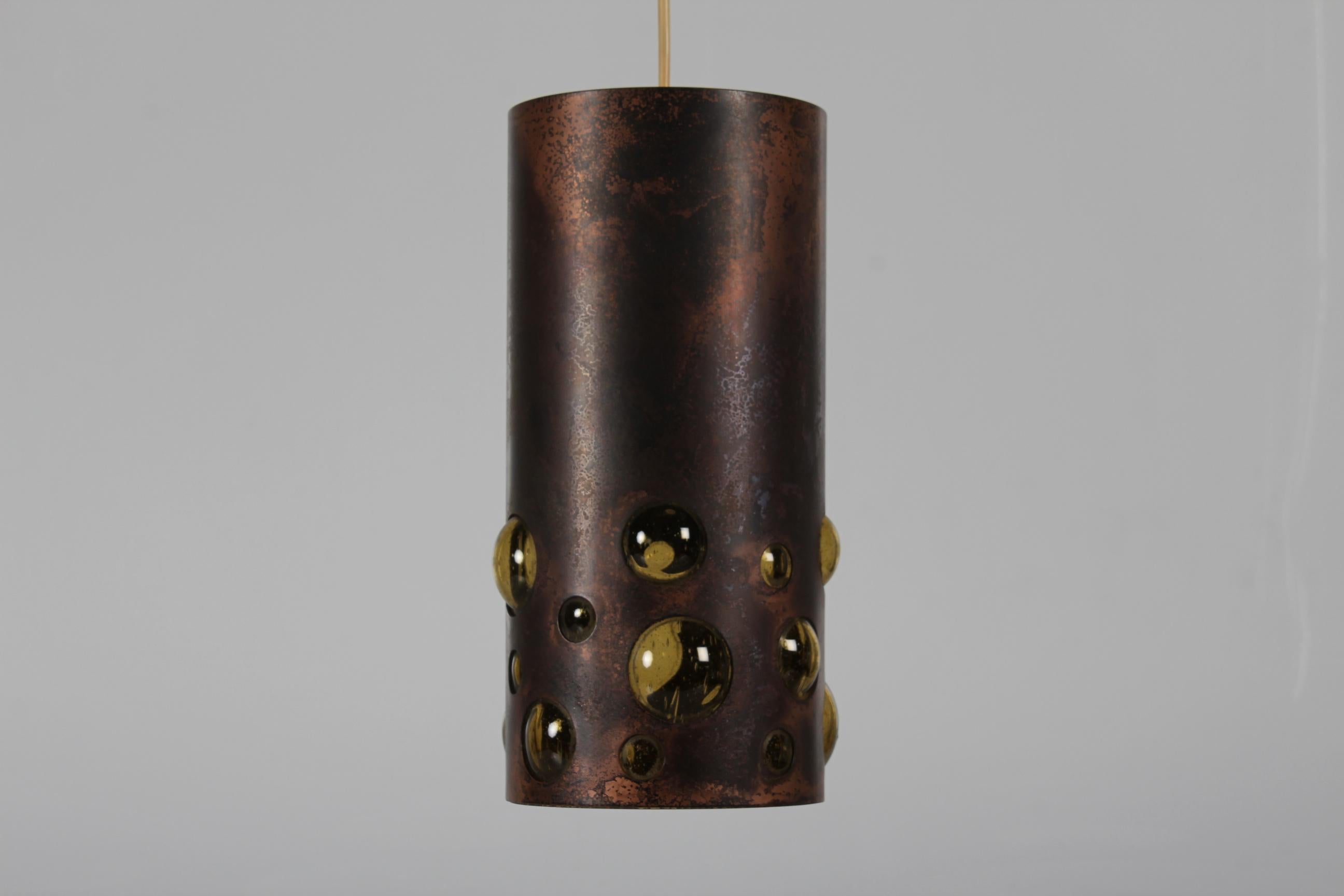 Pendant light made of amber coloured glass covered with patinated copper with perforrations in Nanny Still style 1960´s by RAAK 

Measures: Height 30 cm
Diameter 14 cm

Very nice vintage condition with beautiful patina and full function.

