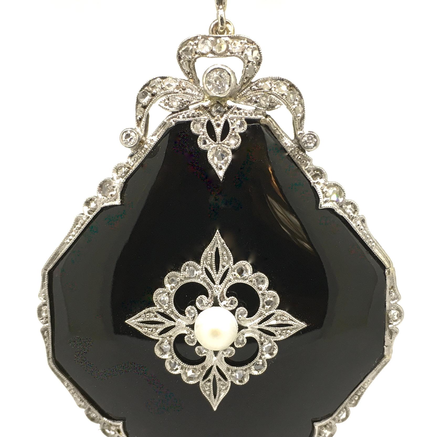 Pendant, Platinum, Belle Epoque, Onyx, Diamond total 0,94 carat.
Measuring 70 mm., long (including the diamond-set loop), this pristine and strikingly stunning French Belle Epoque jewel (circa 1900) is hand-crafted in platinum and features a glossy