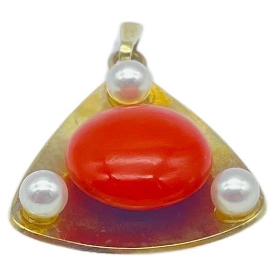 Embark on a journey of aesthetic delight with this breathtaking 14k yellow gold pendant, shaped in a captivating triangle. At its heart, a luscious round coral takes center stage, radiating natural beauty. Adding to the allure, three pearls are