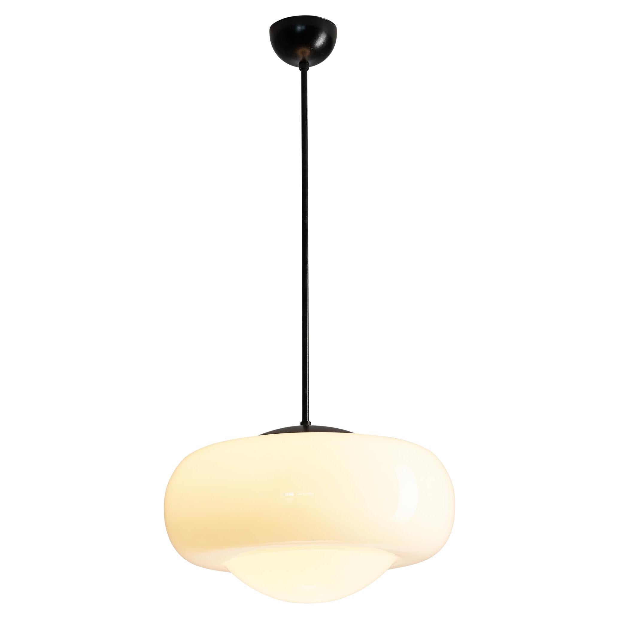 Pendant, opaline glass, metal, Europe, 1960s. 

Eccentric pendant with an oval shaped frosted glass shade. A nice detail of its design is the round shaped bottom side. A black lacquered metal canopy attaches the lamp to the ceiling. Due to the