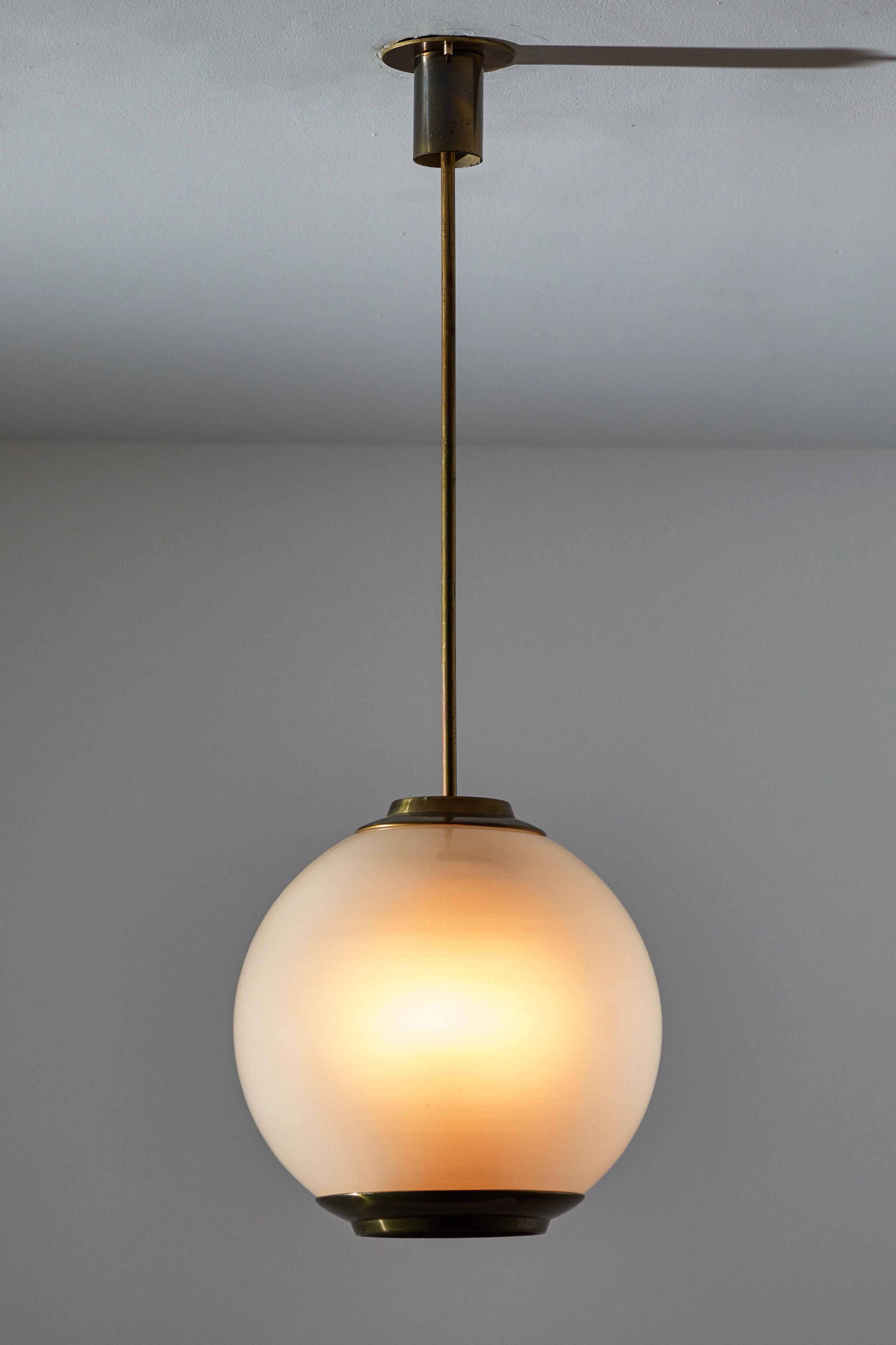 Single pendant by Caccia Dominioni for Azucena. Designed and manufactured in Italy, circa 1950s. Opaline glass diffuser, brass plated stem and canopy. Custom brass ceiling plate. Rewired for US junction boxes. This pendant takes three E27 Candelabra