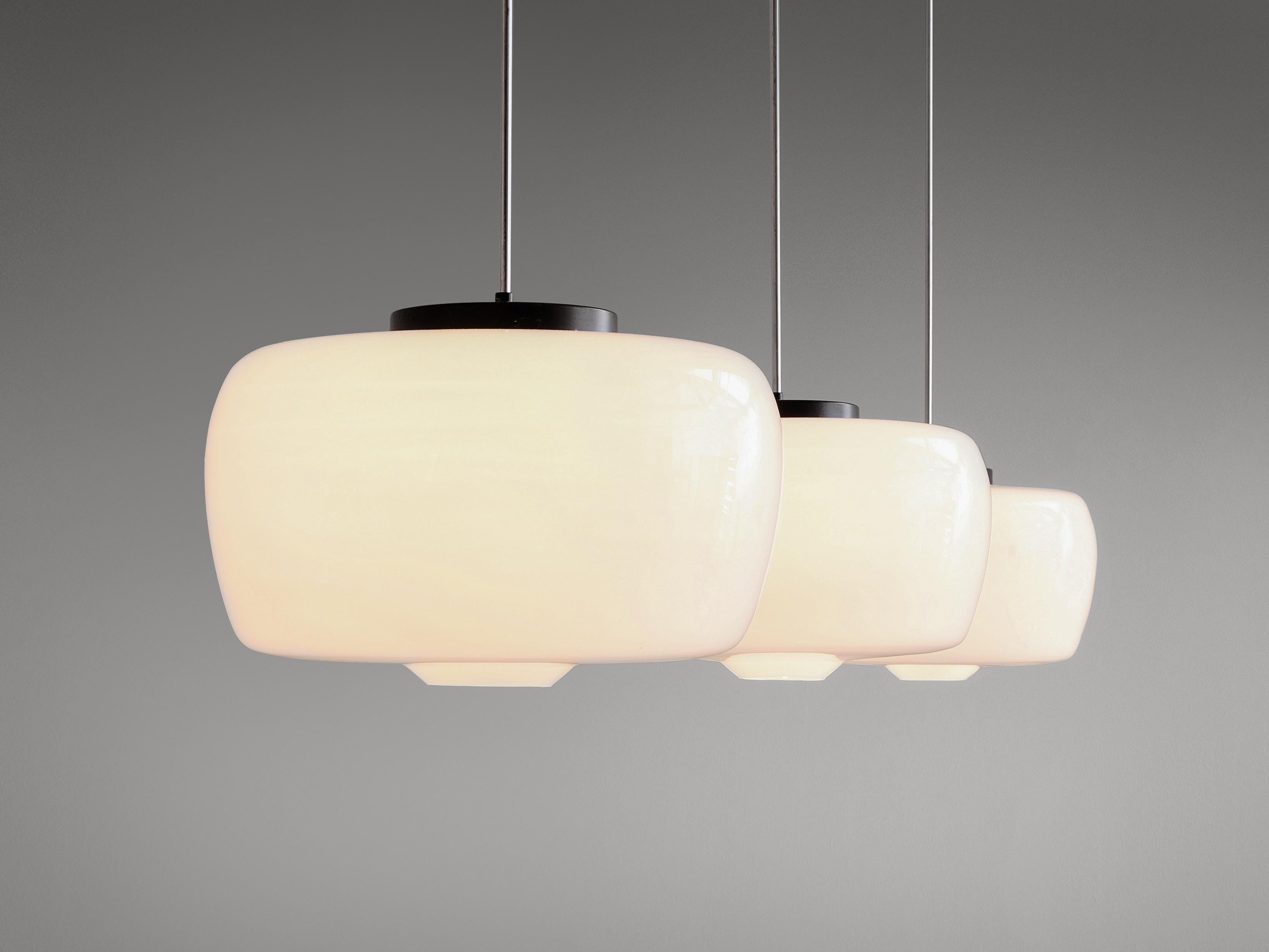 Pendants, opaline glass and metal, European, 1960s. 

Minimalistic and pristine pendants in opaline glass. Great globe shade with flattened top and small opening in the bottom. Black coated top and canopy, metal stern. These pendants provide an