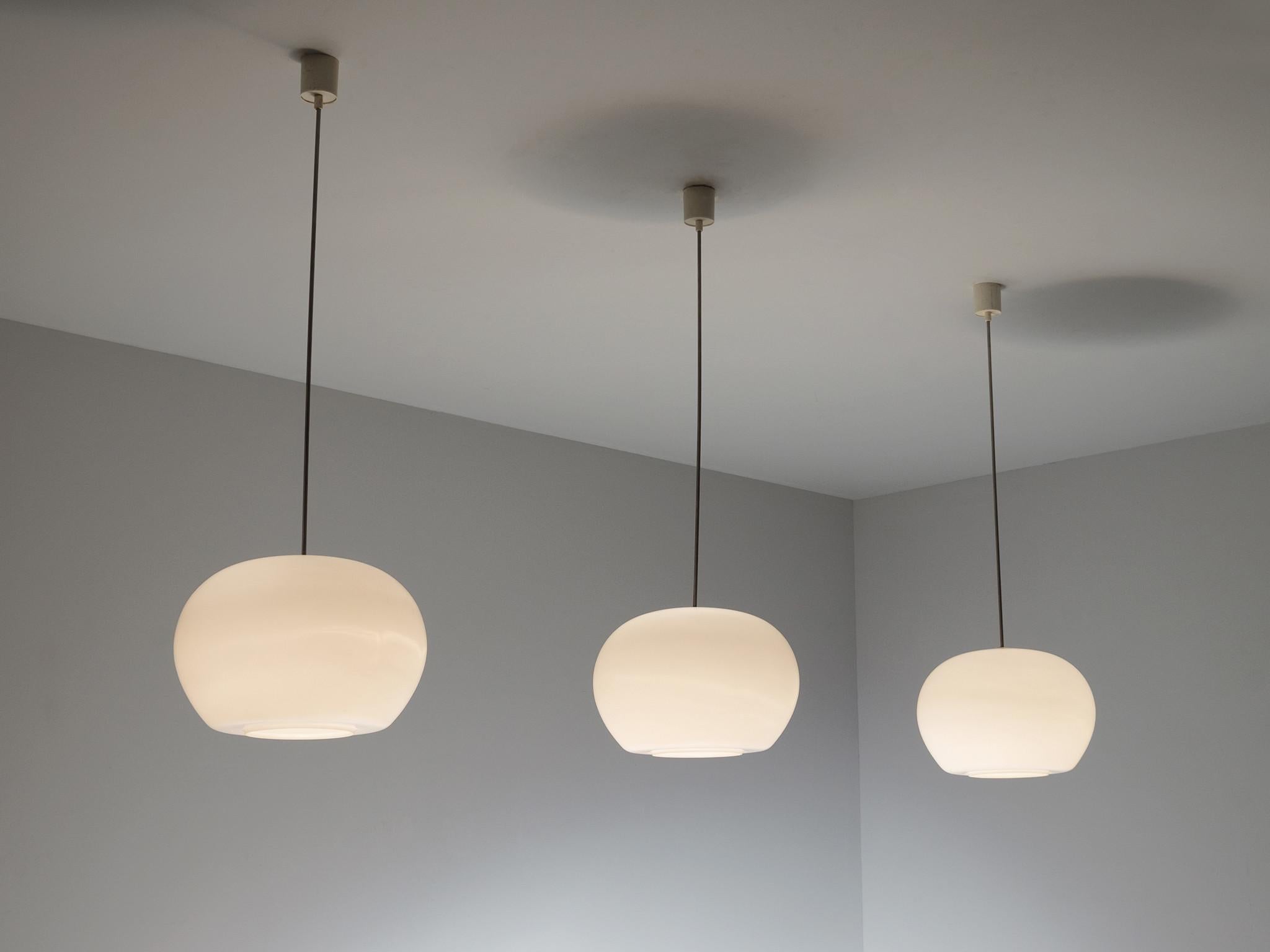 Pendants in metal and opaline glass, Europe, 1970s.

Pendants made in Europe in the 1970s. These lights show a serene appearance because of their opal glass shades. This design is very simplistic and sober, yet these lights create a very warm and