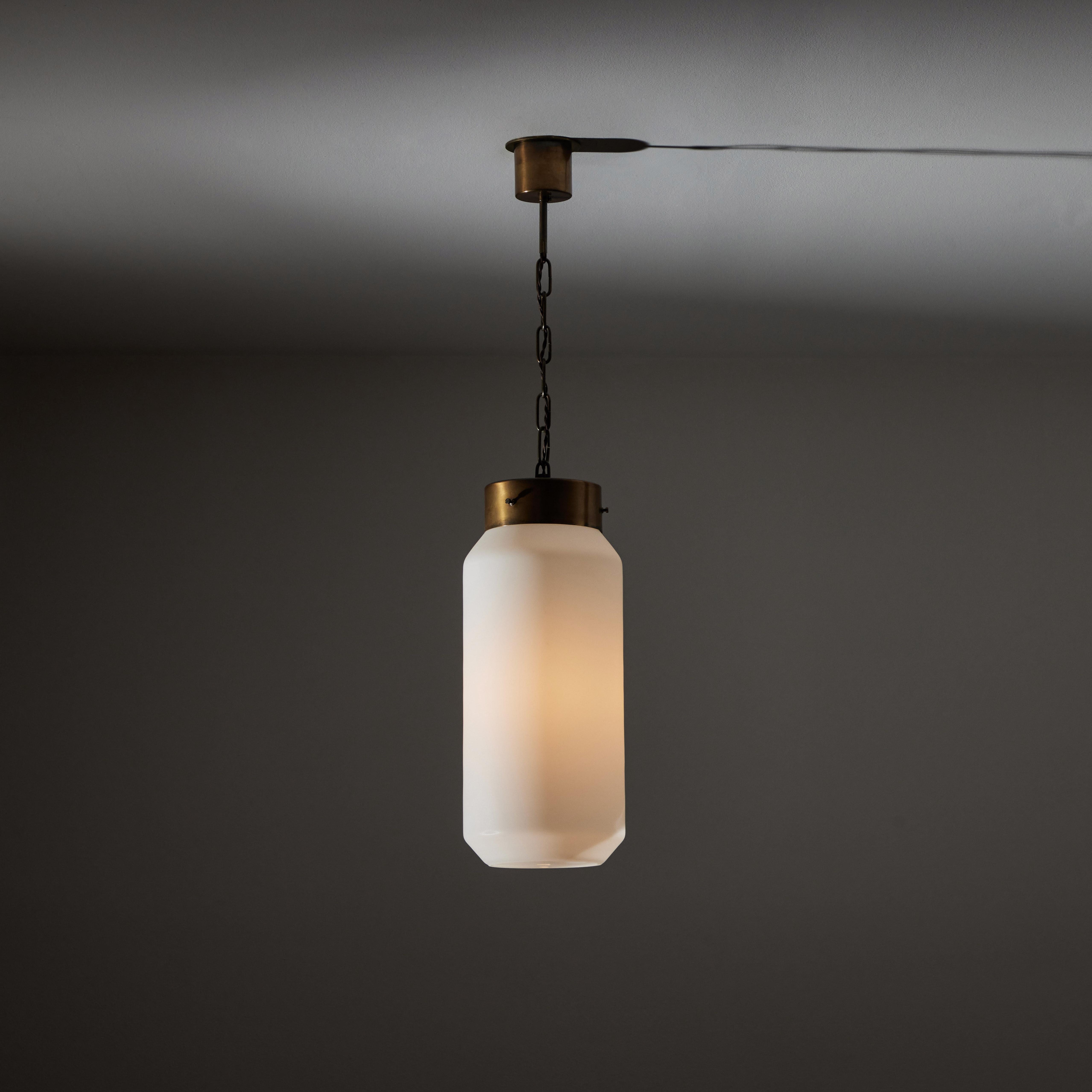 Single Pendant by Caccia Dominioni for Azucena. Designed and manufactured in Italy circa the 1950s. White sandblasted cylinders are suspended by brass chain. Original canopies paired with custom backplate for US standards. Holds one E27 socket type.