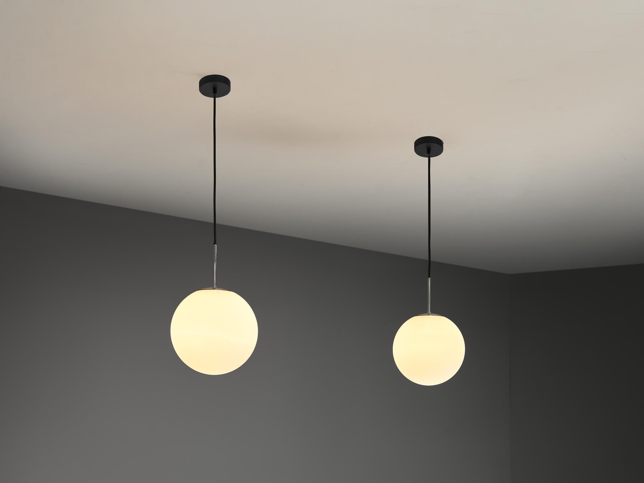 Pendants, glass, metal, Europe 1970s. 

Pair of modern pendants with white glass globe shaped spheres. Overall, an elegant but simplistic design. Due to the opaque texture and the light point, these pendants will create a nice and warm diffuse