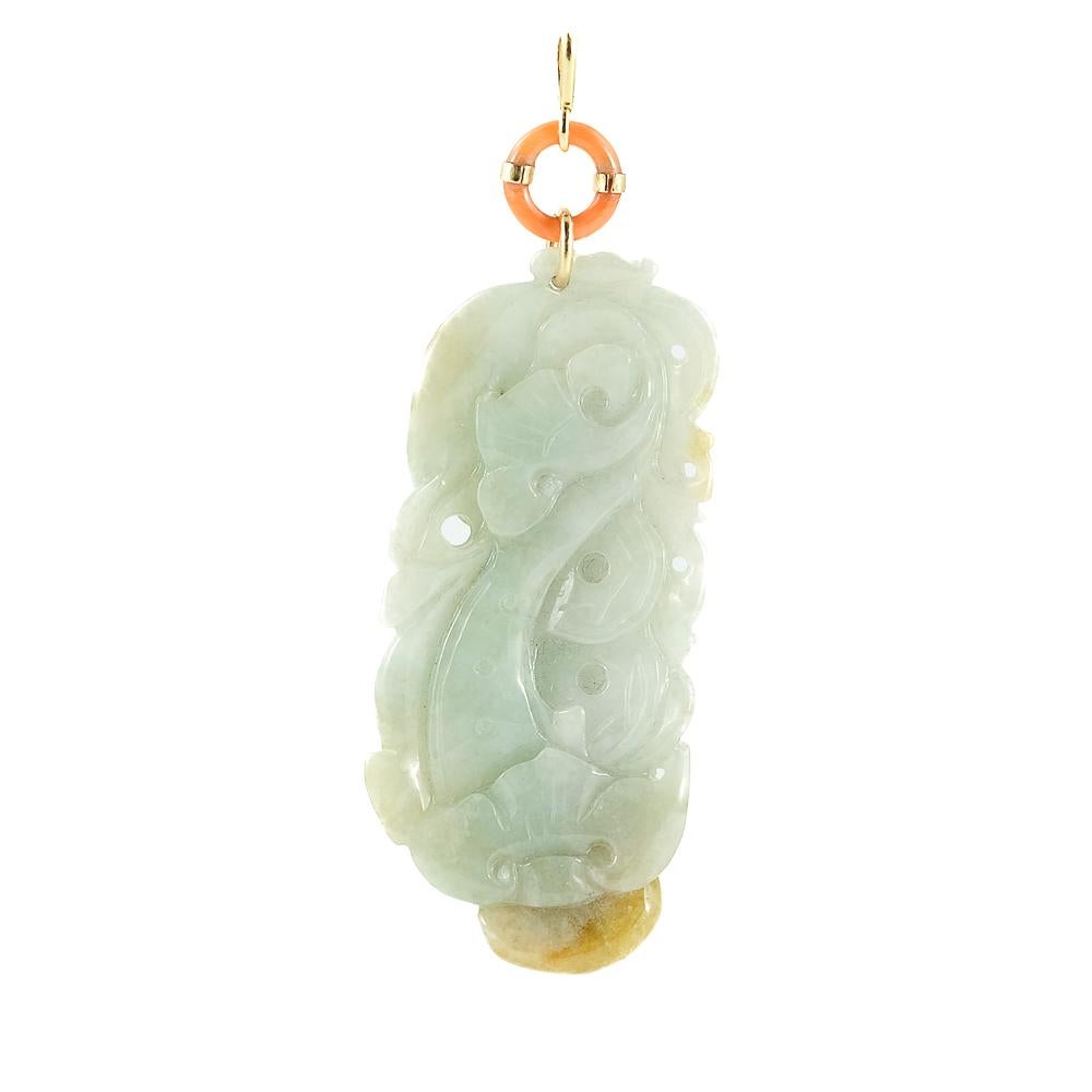 Pendentif élégant composé d'anneaux de corail véritable d'une couleur vibrante et naturelle. Le pendentif est un magnifique jade néphrite naturel, méticuleusement travaillé avec un bas-relief gravé qui ajoute de la sophistication et de l'originalité