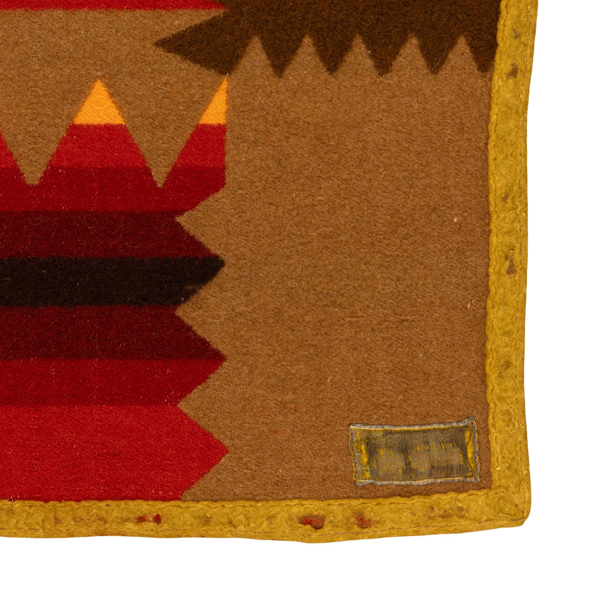 Coperta commerciale in lana Pendleton con resti di Label. Doppio lato con il simbolo dello Shriner. Caratterizzato da disegni geometrici a bande nei colori caldi e brillanti del rosso, del marrone, del giallo e del verde. Sarebbe perfetto in una
