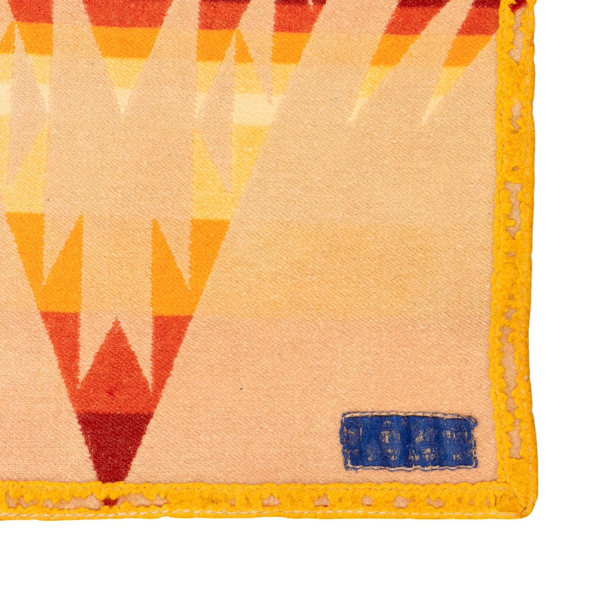 Coperta commerciale in lana a doppia faccia di Pendleton con rilegatura dei bordi e resti di Label. I colori sono audaci e vivaci, con bande di colore giallo, rosso e arancione con cristalli e disegni geometrici sovrapposti. Ideale per una casa del
