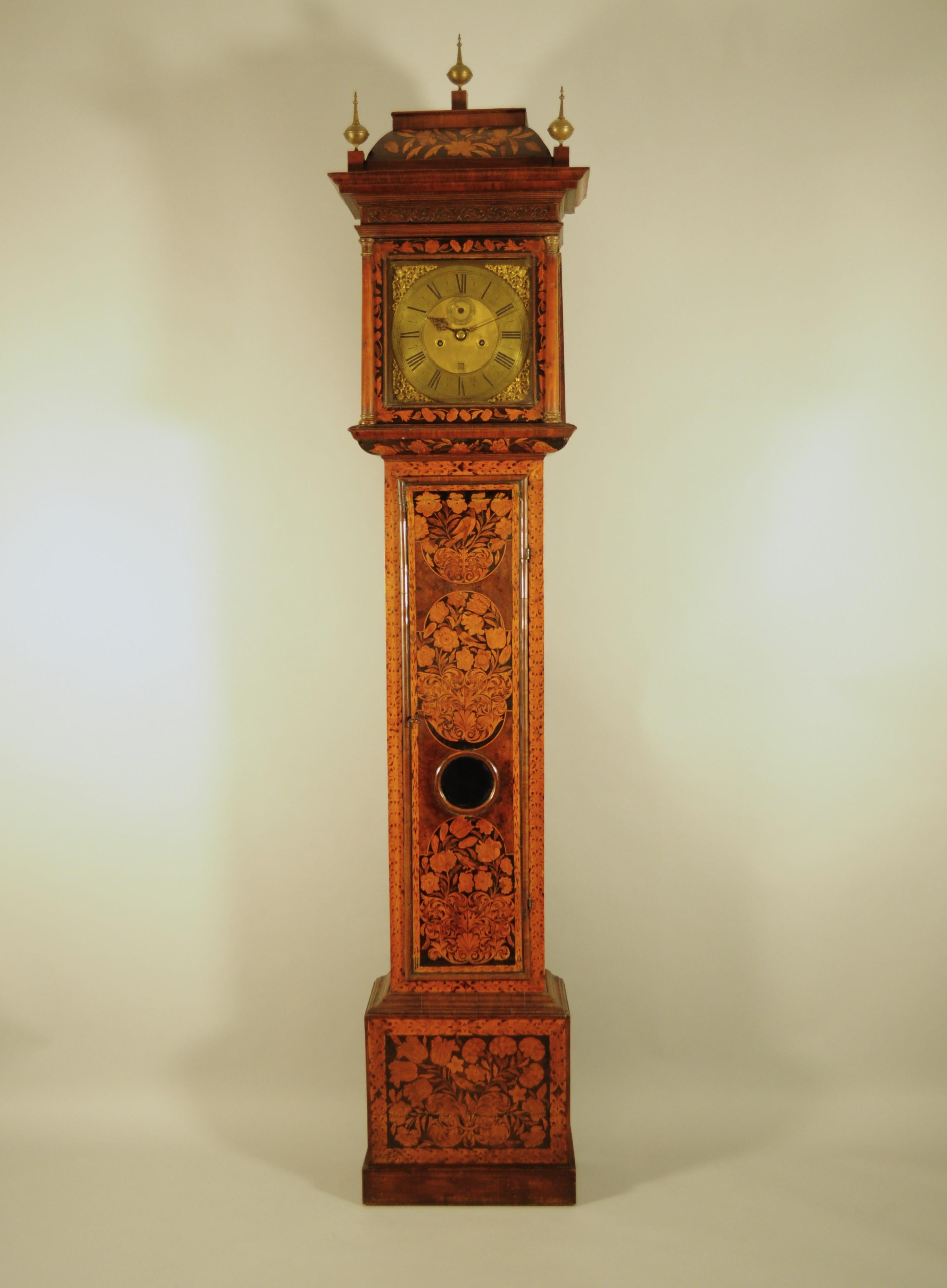 Antique English column clock with chime.
Long-stemmed case inlaid with fine woods in plant and bird motifs. Three beautiful metal pinnacles decorate the cymatium. Original glazing. 
Gilded metal dial embellished with pierced and engraved gilded