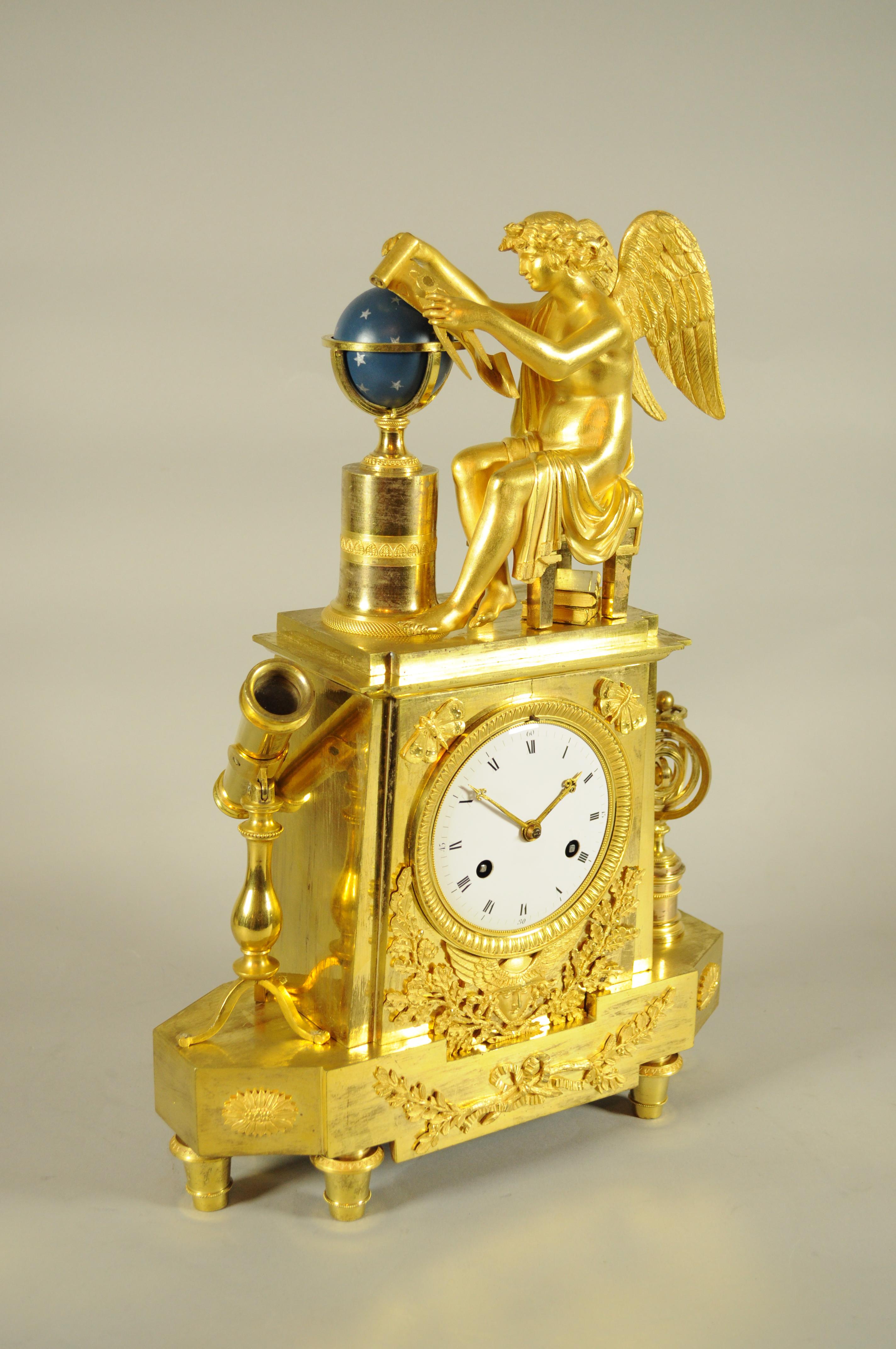 Antica pendola francese rappresentante l'allegoria dell'Astronomia con cassa in bronzo dorato e globo celeste blu. Various elements recall the theme of astronomy: seated intent on studying the celestial globe we find the winged god of the stars