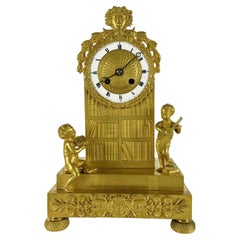 Französische Empire Pendeluhr aus vergoldeter Bronze Anfang 1800 mit Putti und Bücherregal