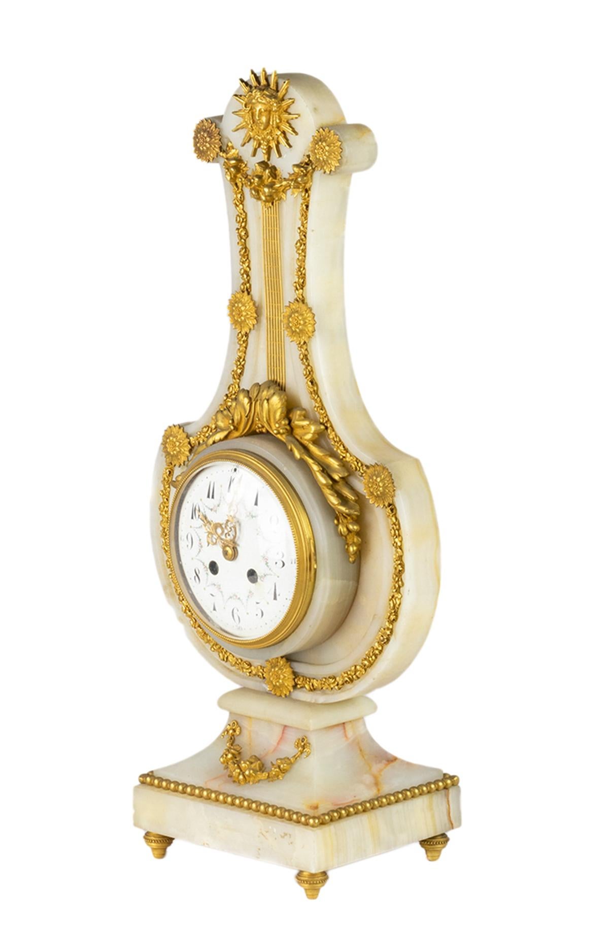 Large Lyre Pendulum clock in white marble, rich ornamentation of very finely chiseled and gilded bronzes such as garlands of flowers, draped garlands, rosettes and acanthus leaves.

The marble Lyre is surmounted by a radiant neoclassical mask from