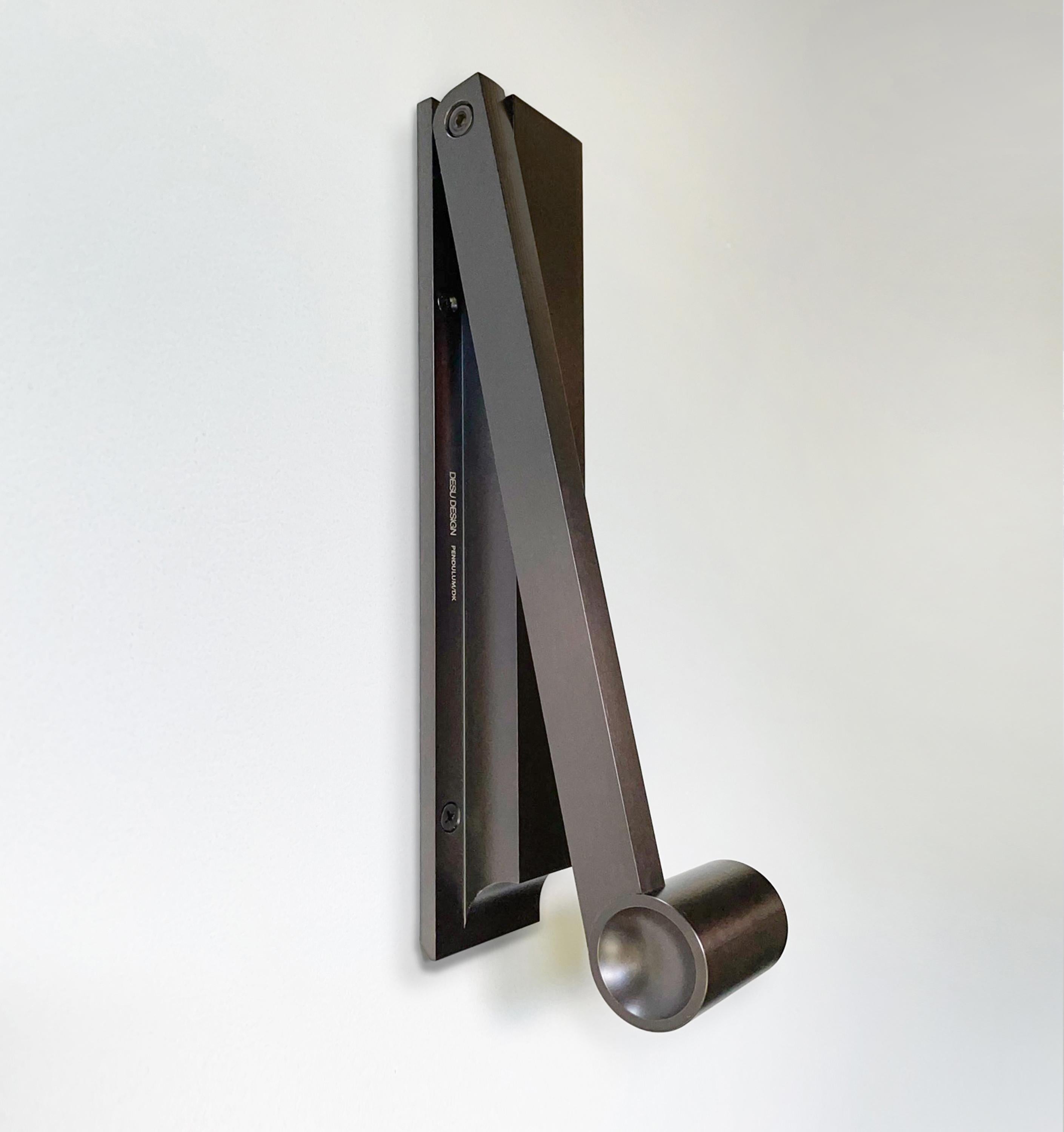The sculptural Pendulum door knocker brings old world craftsmanship and unadorned utility together to create minimalist art. The hefty weight of the handle feels good in your hand, and has slightly recessed sides to intuitively grasp. Designed by
