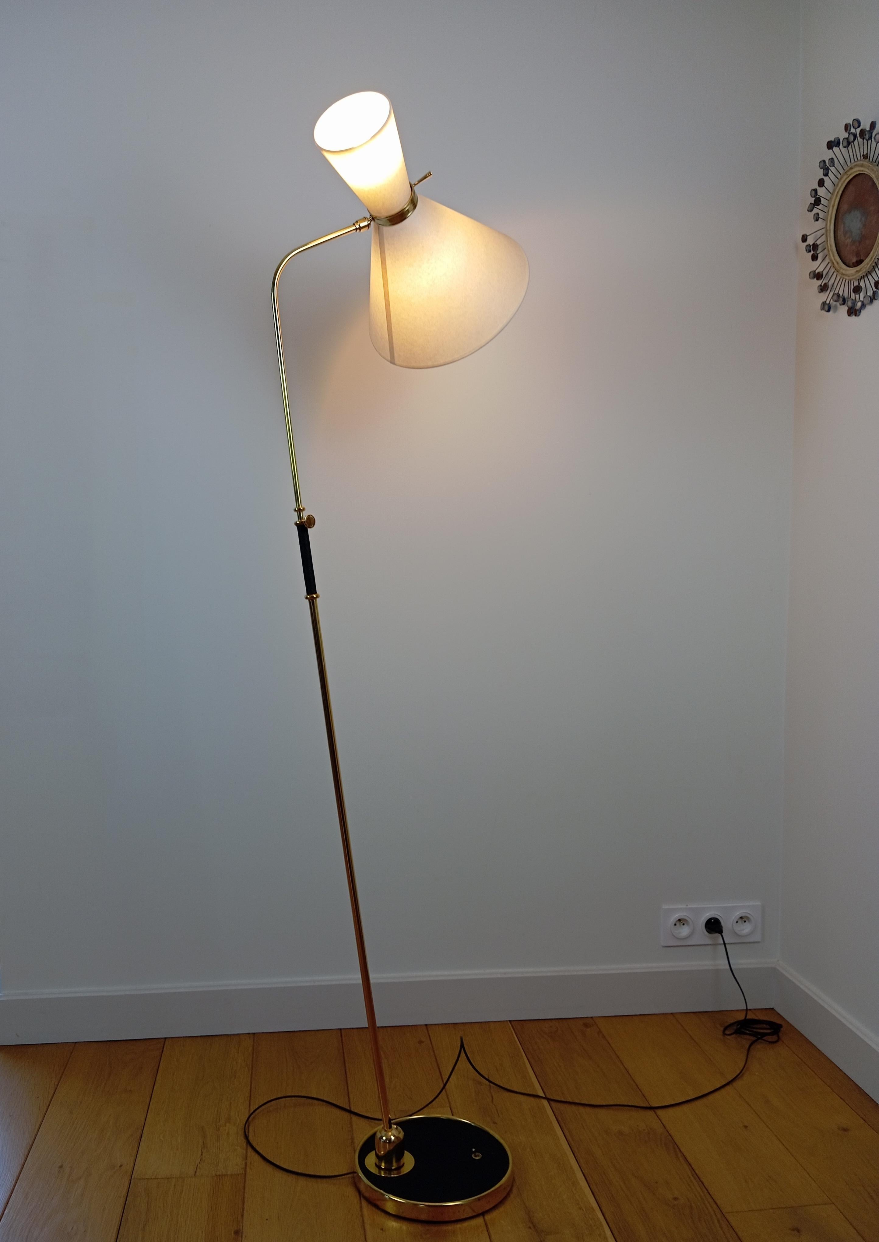  fFoor lamps,
composed of a circular base in cast iron sheathed in black leather, and set with a brass ring.
Brass arm with adjustable height, and orientable by a brass ball joint on the base of the foot.
Lighting by 2 conical shades, installed on a