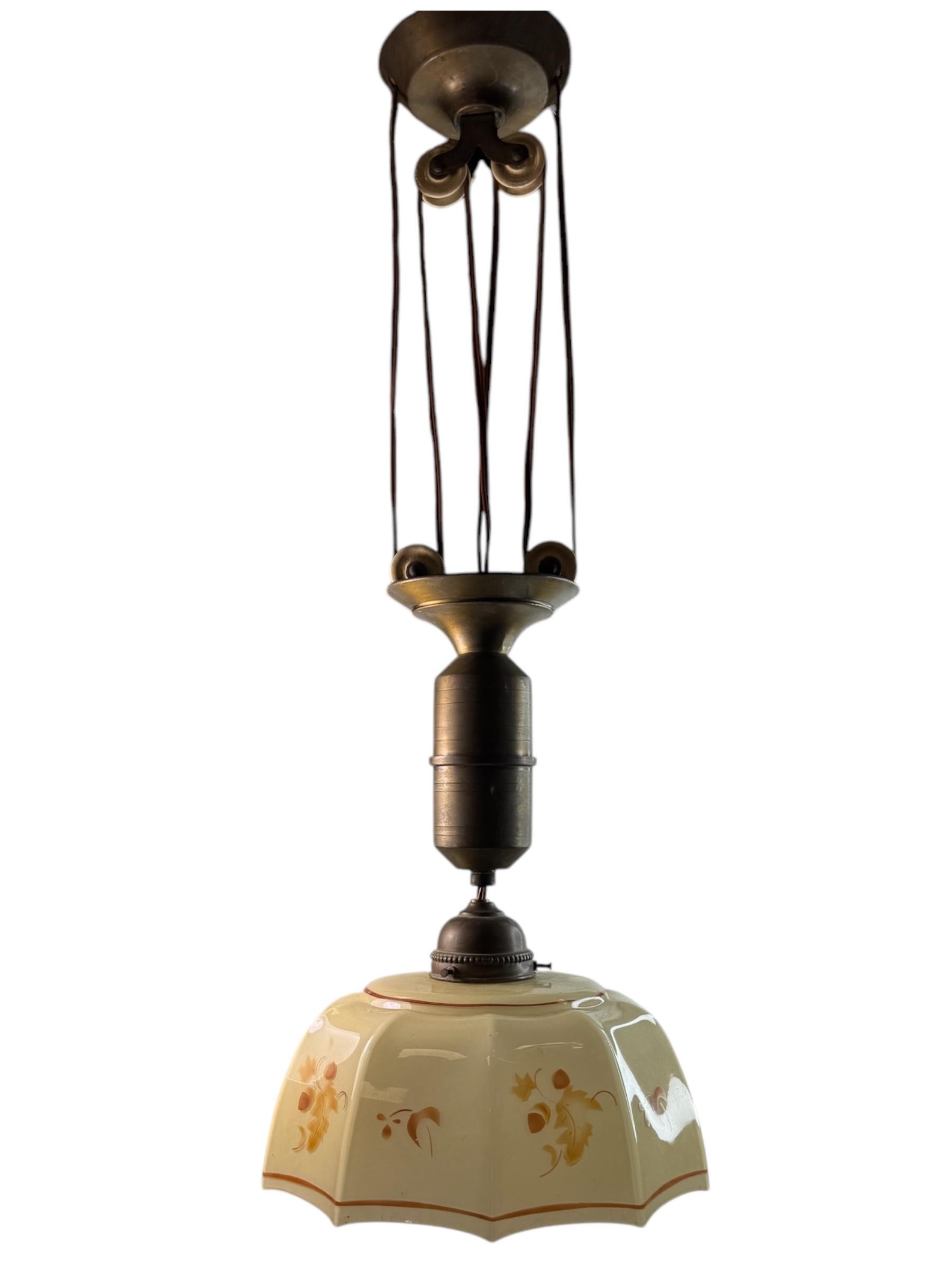 Stunning exceptional glass and Iron pendant light . Made in Germany, circa 1920s by a Lighting Company.
The combination of brown-black iron suspension, decorative elements made of white ceramic and a shade made of art deco glass make the Provence