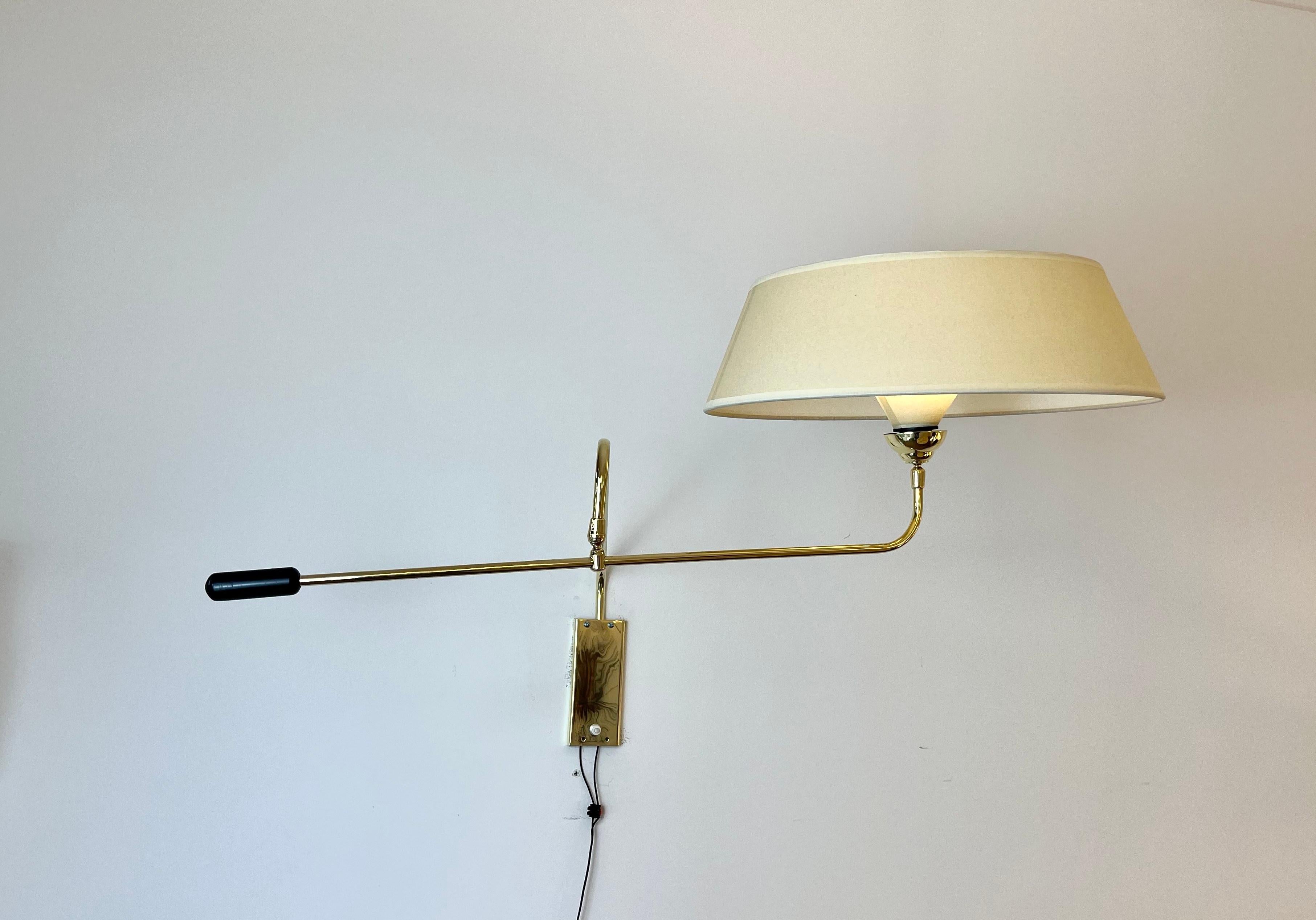 Sconces with pendulum, in brass, composed of a rectangular brass base, on which is placed a brass sconce pivoting from right to left.
Another arm articulated by a brass ball, allows the orientation of the shade.
A black metal handle allows the